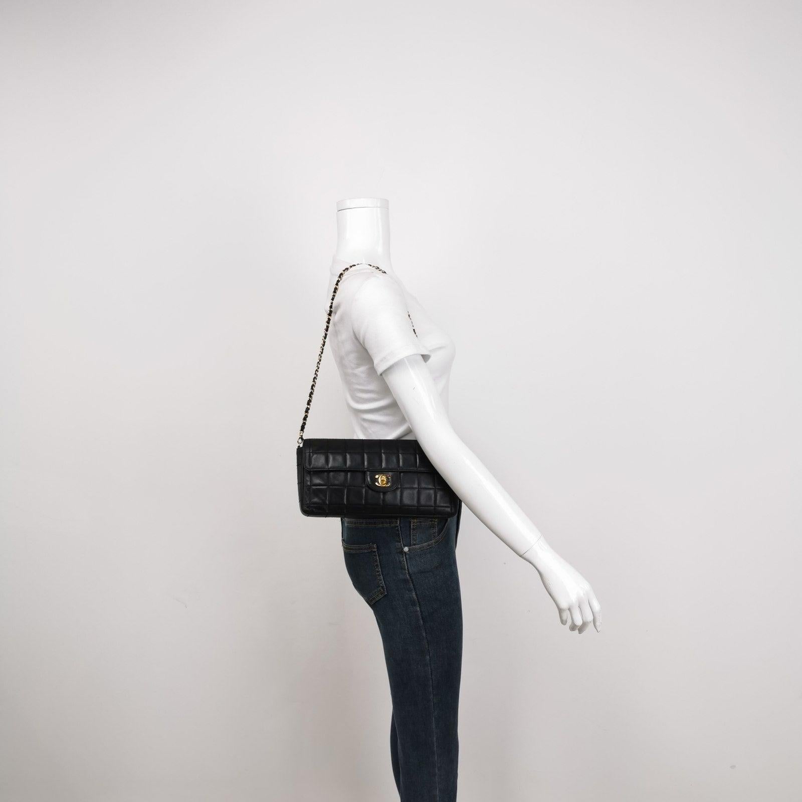 Chanel East West Chocolate Bar Black Leather
  These are professional photos of the actual bag.
  This charming Vintage Chanel East West Leather Shoulder Bag is a stylish mix of classy and casual. The elongated shape gives its 