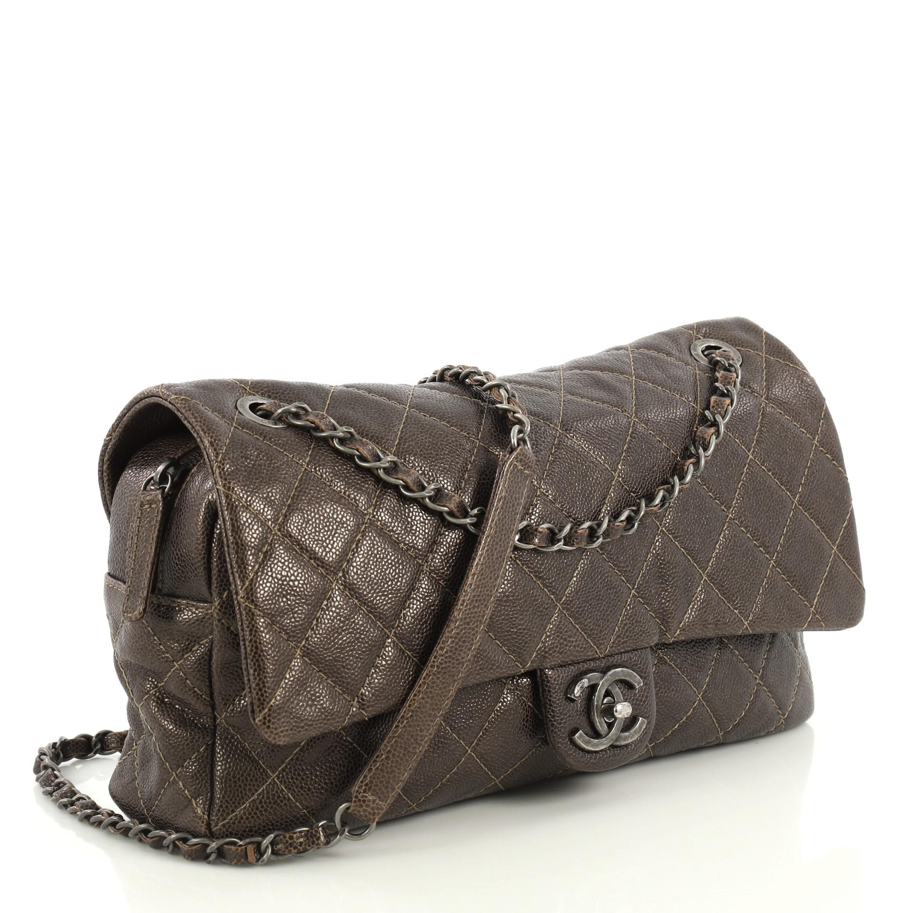 This Chanel Easy Flap Bag Quilted Caviar Jumbo, crafted from brown quilted caviar leather, features woven-in leather chain strap with leather pad, frontal flap, and aged silver-tone hardware. Its CC turn-lock closure opens to a black fabric interior