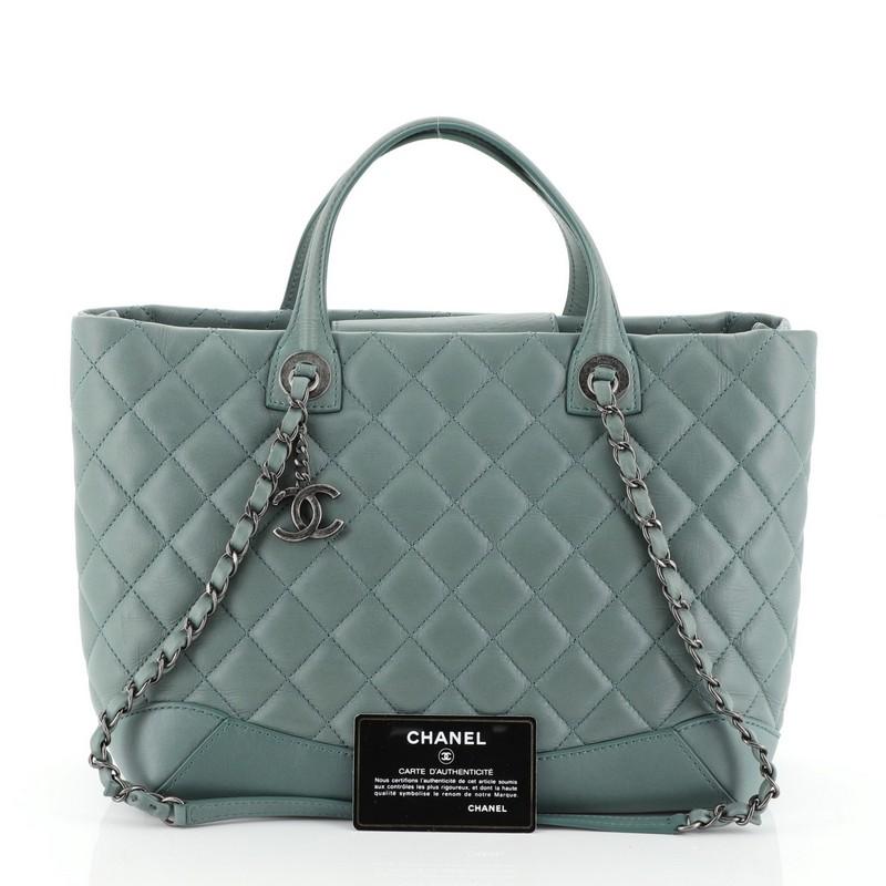 This Chanel Easy Shopping Tote Quilted Calfskin Medium, crafted from green quilted calfskin leather, features dual flat top handle, dual woven-in leather chain link straps with shoulder pads, and aged silver-tone hardware. Its magnetic closure opens