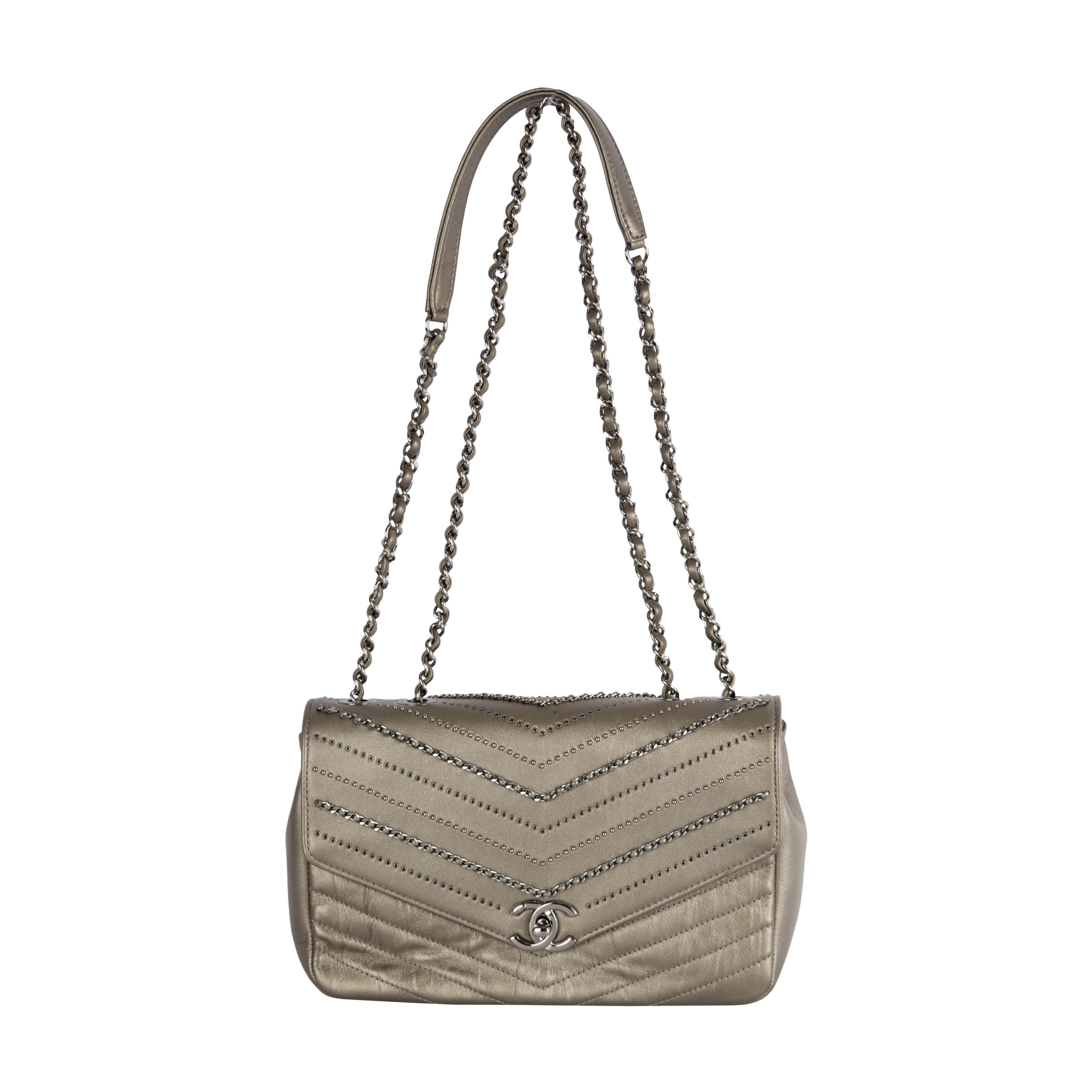 Die Chevron Flap Bag von Chanel aus der Herbst/Winter-Kollektion 2018 ist aus Kalbsleder in Silbermetallic gefertigt, das einen glitzernden Look und eine faszinierende Textur aufweist. Es verfügt über verzierte Ketten, die mit Lederriemen und