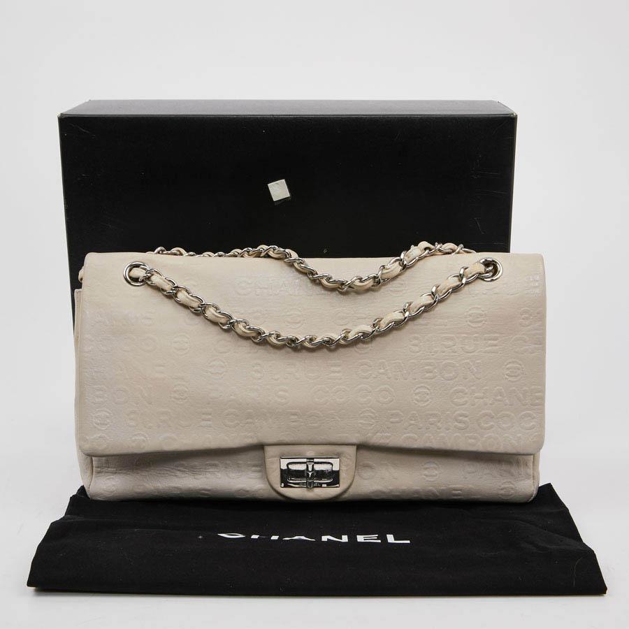 This big CHANEL bag is in beige embossed leather. On the leather is marked 