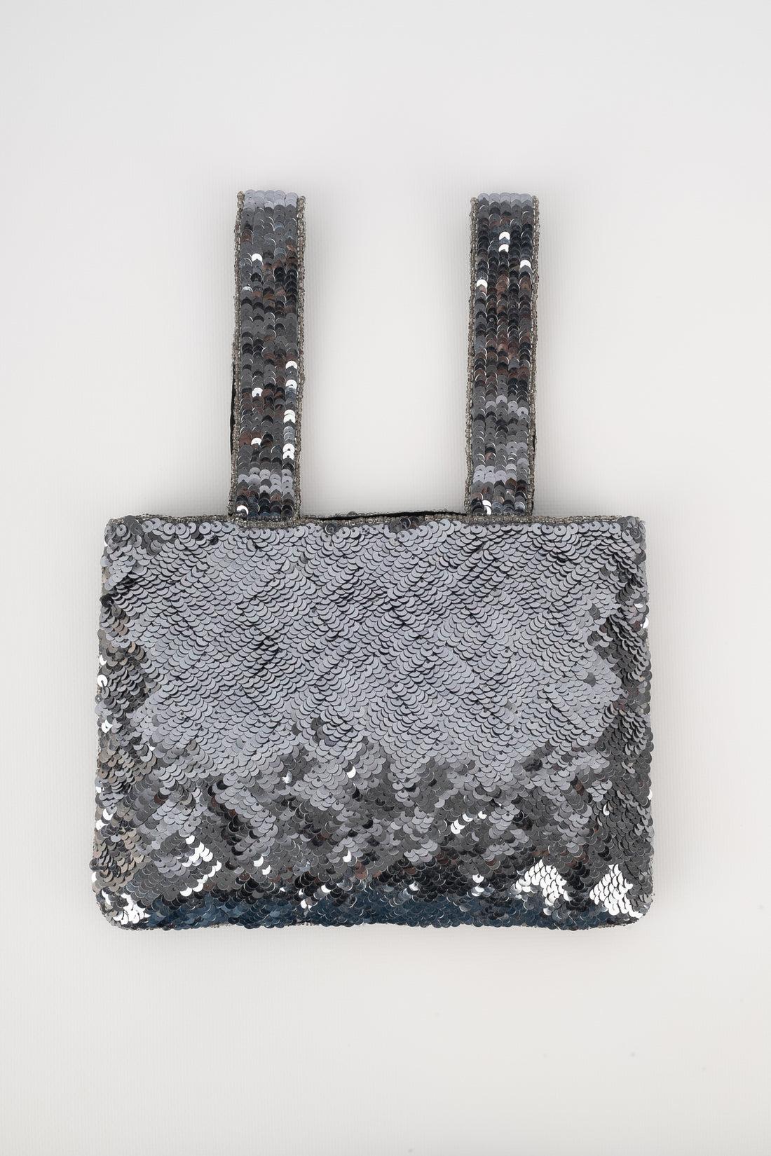Chanel - (Made in France) 'Trompe l'oeil' bag entirely embroidered with silvery sequins and coordinated pearls. Piece with a serial number and an authenticity certificate. A 1997/1999 Collection, under the direction of Karl Lagerfeld.

Additional