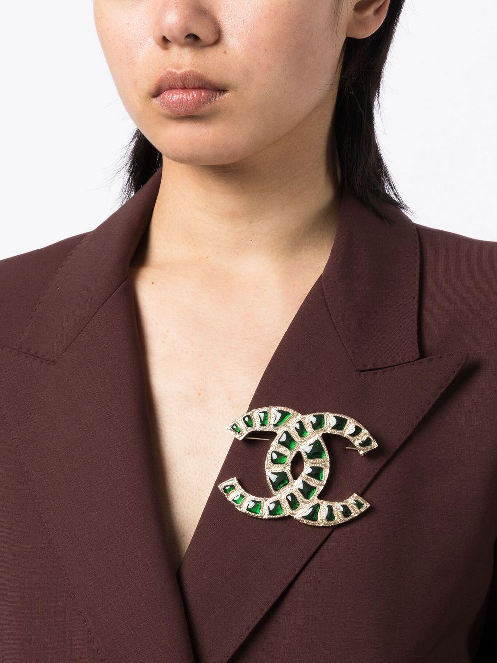 This exquisite Emerald Green CC Stone-Embellished Brooch from Chanel is crafted from gold-plated metal and glass and features the signature interlocking CC logo and a bar-pin fastening. From Fall 2018, this large brooch is the perfect finishing