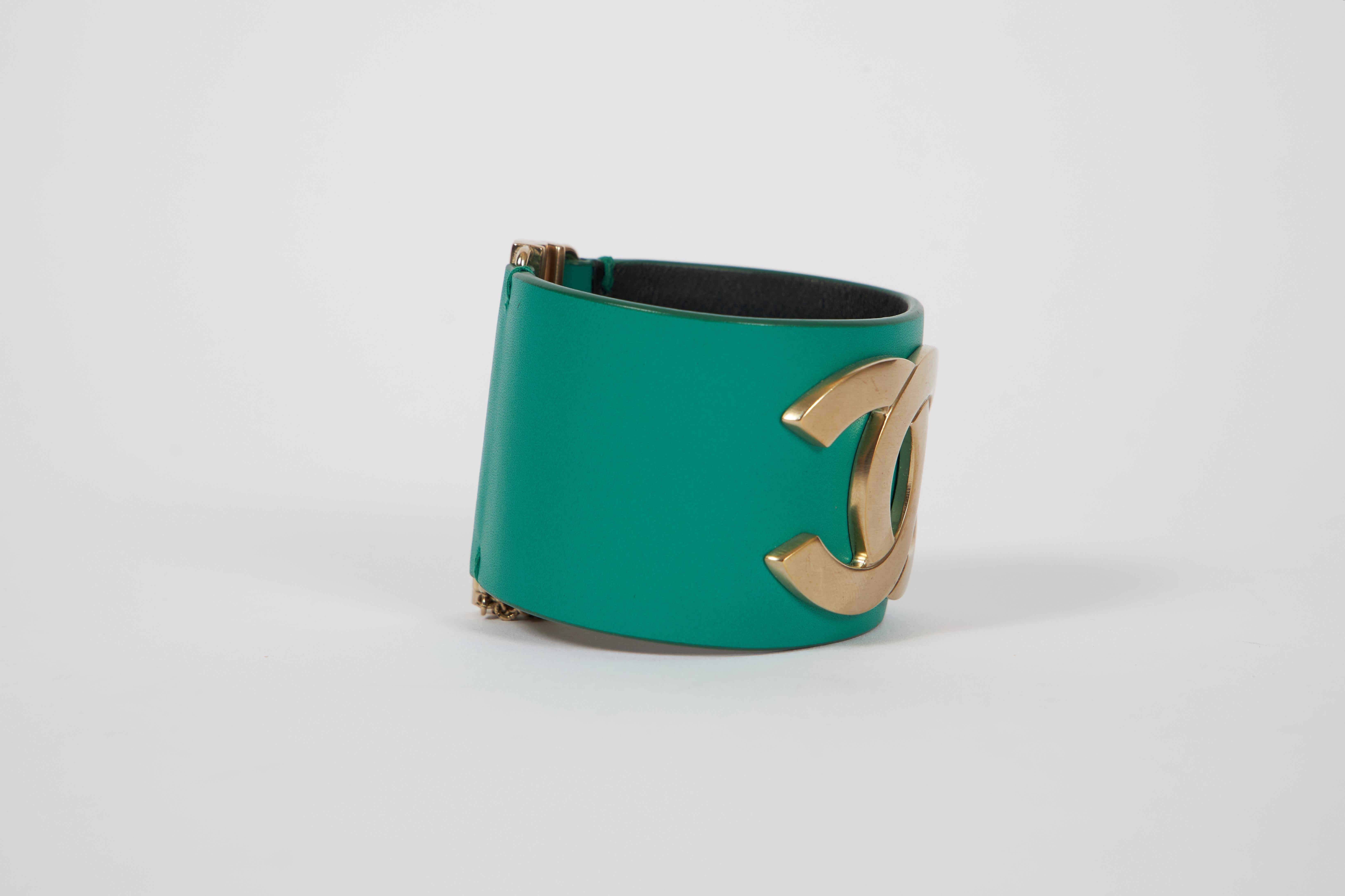Chanel emerald green leather cuff with a satin silver finish logo. 7.25