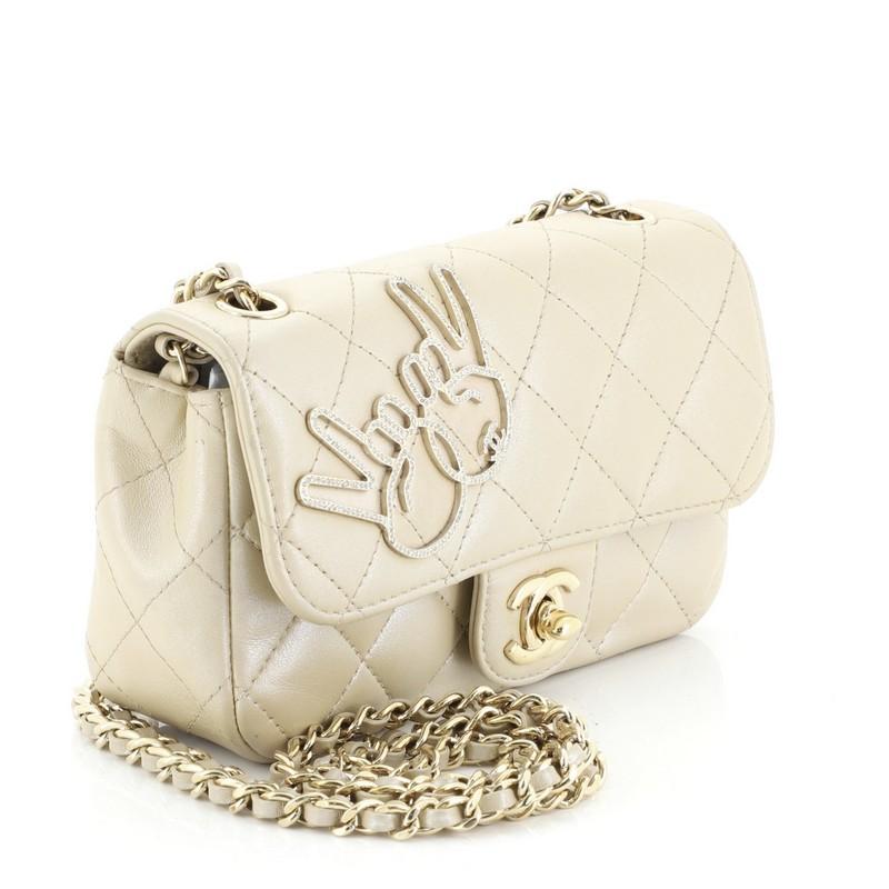 This Chanel Emoticon Classic Single Flap Bag Quilted Lambskin Extra Mini, crafted from neutral leather, features woven-in leather chain strap, exterior back pocket and gold-tone hardware. Its CC turn lock closure opens to a neutral leather interior