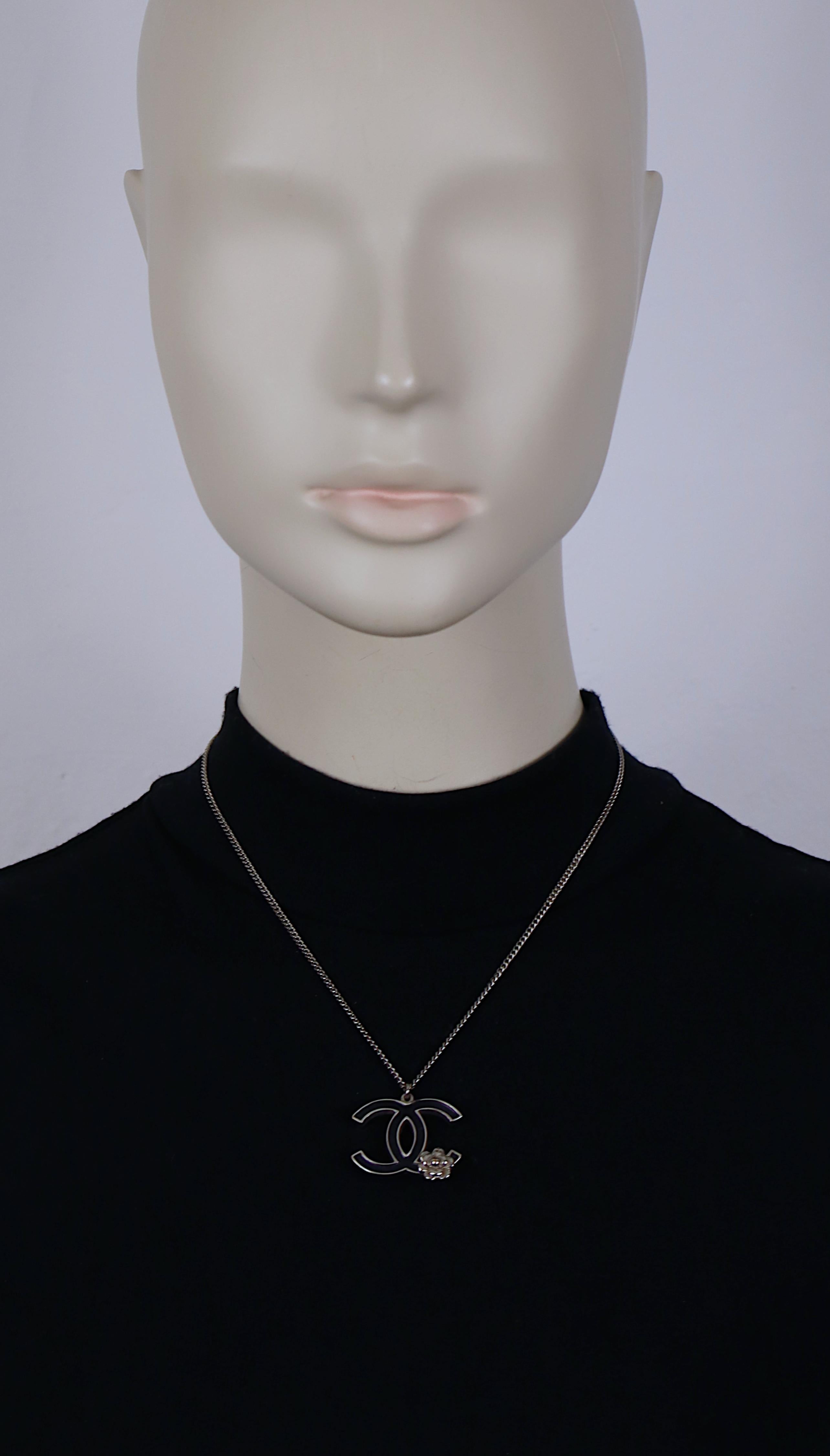 Collana con ciondolo a catena in tonalità argento di Chanel con logo CC in smalto nero e dettaglio di fiore di camelia.

Chiusura a moschettone.

Chanel P in rilievo Made in France.

Misure indicative: lunghezza della catena circa 42,5 cm (16,73