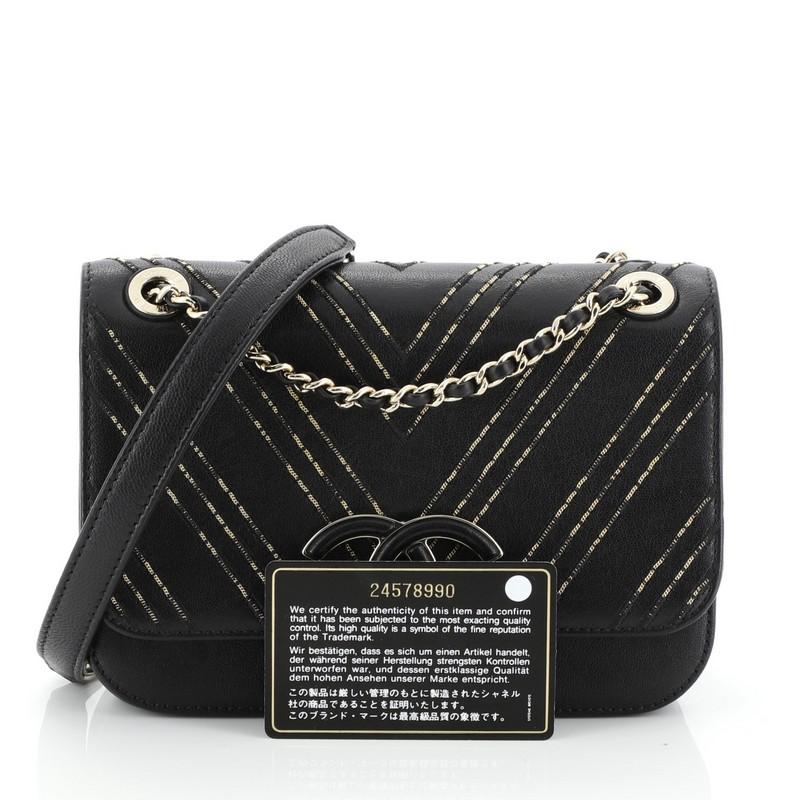 This Chanel Enamel CC Flap Bag Beaded Chevron Sheepskin Medium, crafted from black leather, features woven-in leather chain strap, front flap with large enamel CC tab closure, and gold-tone hardware. It opens to a neutral leather interior. Hologram