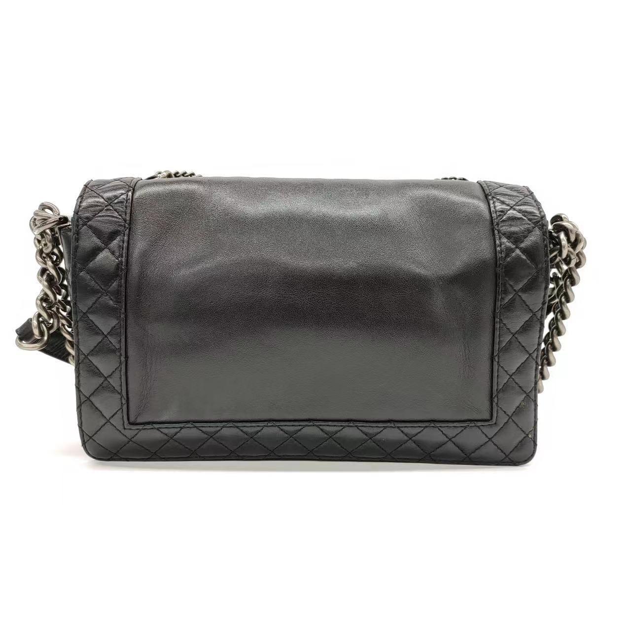 Chanel Enchained Boy Bag 2012 Black Leather Medium Flap Bag Ce sont des photos professionnelles du sac réel offert par Luxbags. Confectionné en cuir d'agneau noir et orné de chaînes en métal argenté, ce sac Boy Enchained de Chanel est à la fois