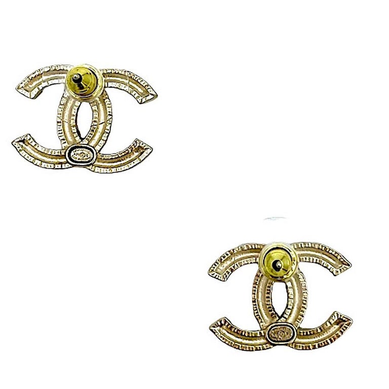 CHANEL Engraved C H A N E L Stud Earrings in Pale Gilt Metal. at