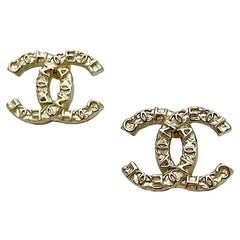 CHANEL Engraved C H A N E L Stud Earrings in Pale Gilt Metal.