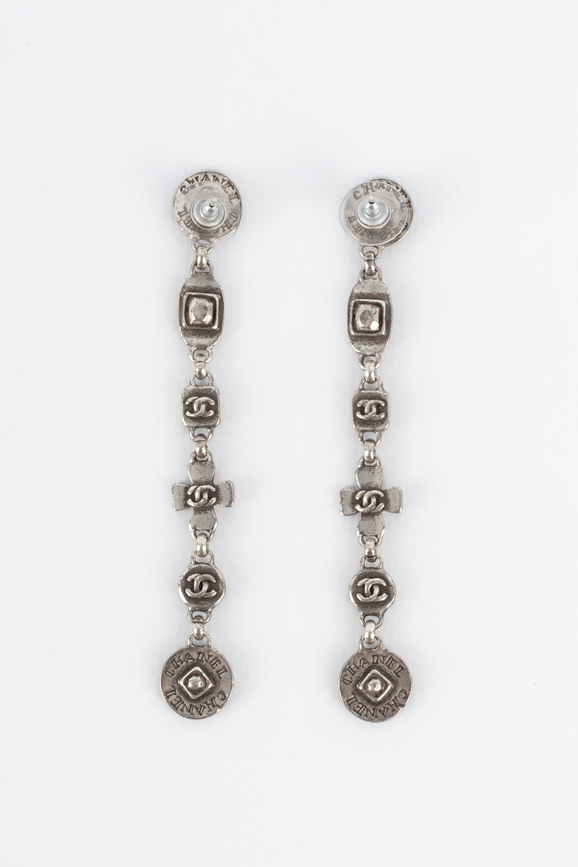Chanel - (Made in France) Engraved silvery metal earrings. 1999 Spring-Summer Collection.
 
 Additional information: 
 Condition: Very good condition
 Dimensions: Length: 9 cm
 Period: 20th Century
 
 Seller Reference: BOB142

