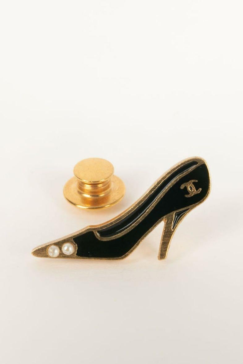 Chanel -(Made in France) Pin's representing a pump in gold metal enamelled with black. 
Fall/Winter 2002 collection.
Brooch designed by Karl Largerfeld for Chanel. 
Work by the Woloch workshop. 

Additional information:

Dimensions: 
Length: 3