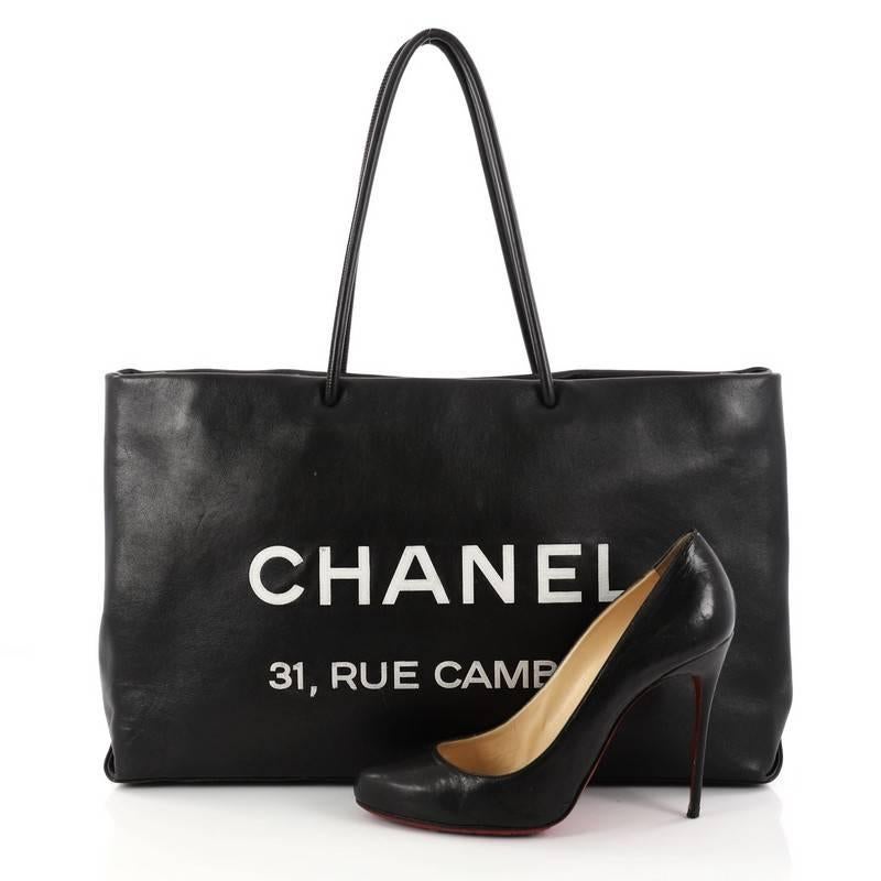This authentic Chanel Essential 31 Rue Cambon Shopping Tote Leather Medium is a minimalist shopping bag perfect for toting all of your belongings. Crafted in black leather, this chic bag features dual-rolled leather handles, Chanel logo and Parisian