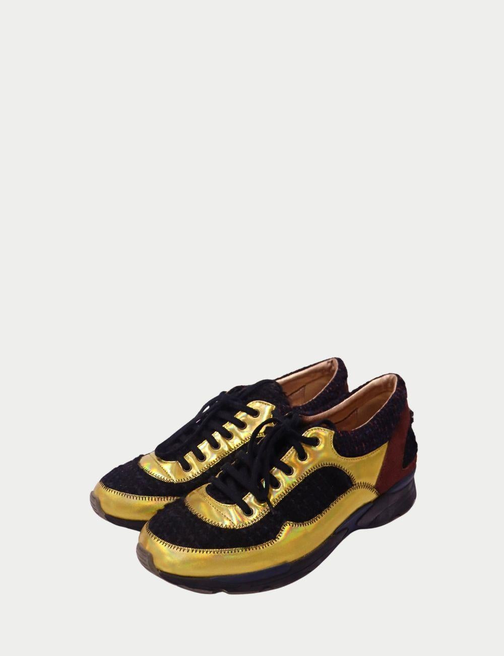 Añade un toque atrevido a la ropa informal con estas zapatillas Chanel con cordones, que combinan la artesanía de lujo con un estilo llamativo. Con paneles de piel dorada metalizada, el clásico tejido de tweed negro y detalles de ante marrón, estas