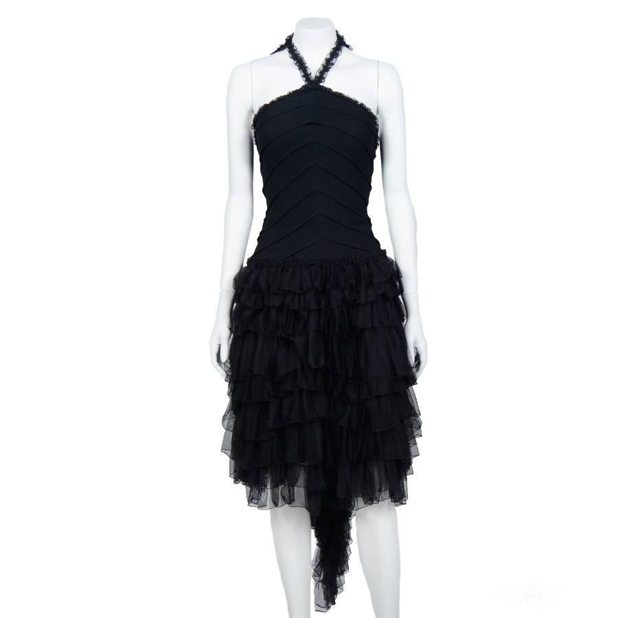 Sublime Chanel evening dress with black ruffles, from the 2002 Cruise Collection. Size 34FR

This dress bare back, close to the body (stretchy material), leaves in ruffles at the hips and ends with a pan also composed of ruffles, acting as a short