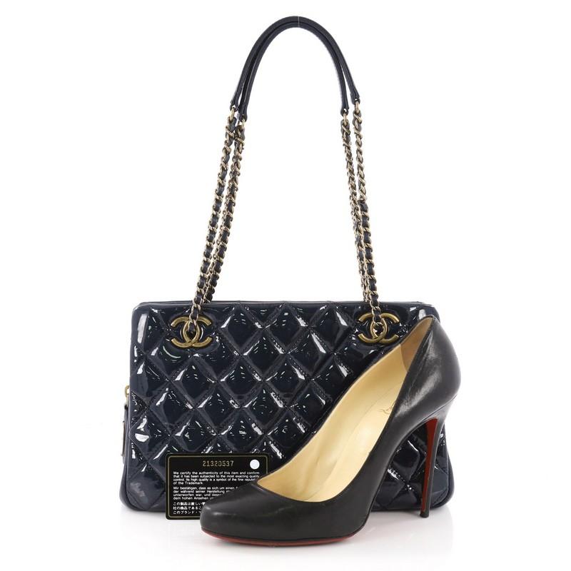 This Chanel Eyelet Tote Quilted Patent Small, crafted in blue quilted patent leather, features woven-in leather chain straps with leather pads, CC logo on eyelets and aged gold-tone hardware accents. Its opens to a  burgundy fabric interior divided