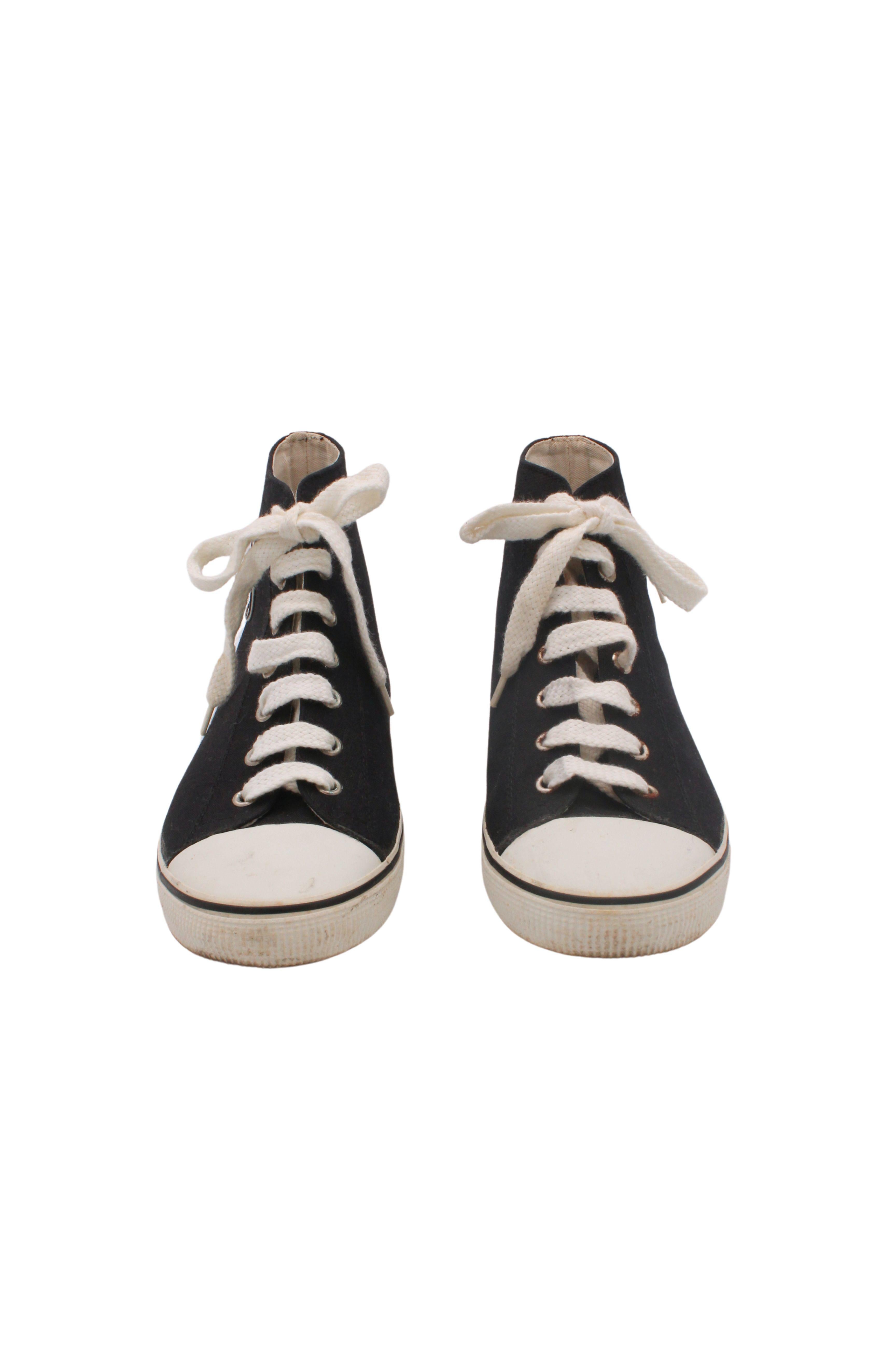 Datant de la collection F/W 1995, ces baskets Chanel rares et classiques sont réalisées en toile noire avec des semelles et des orteils en caoutchouc blanc et présentent un logo CC noir sur blanc sur le côté de la cheville et une plaque logo CHANEL