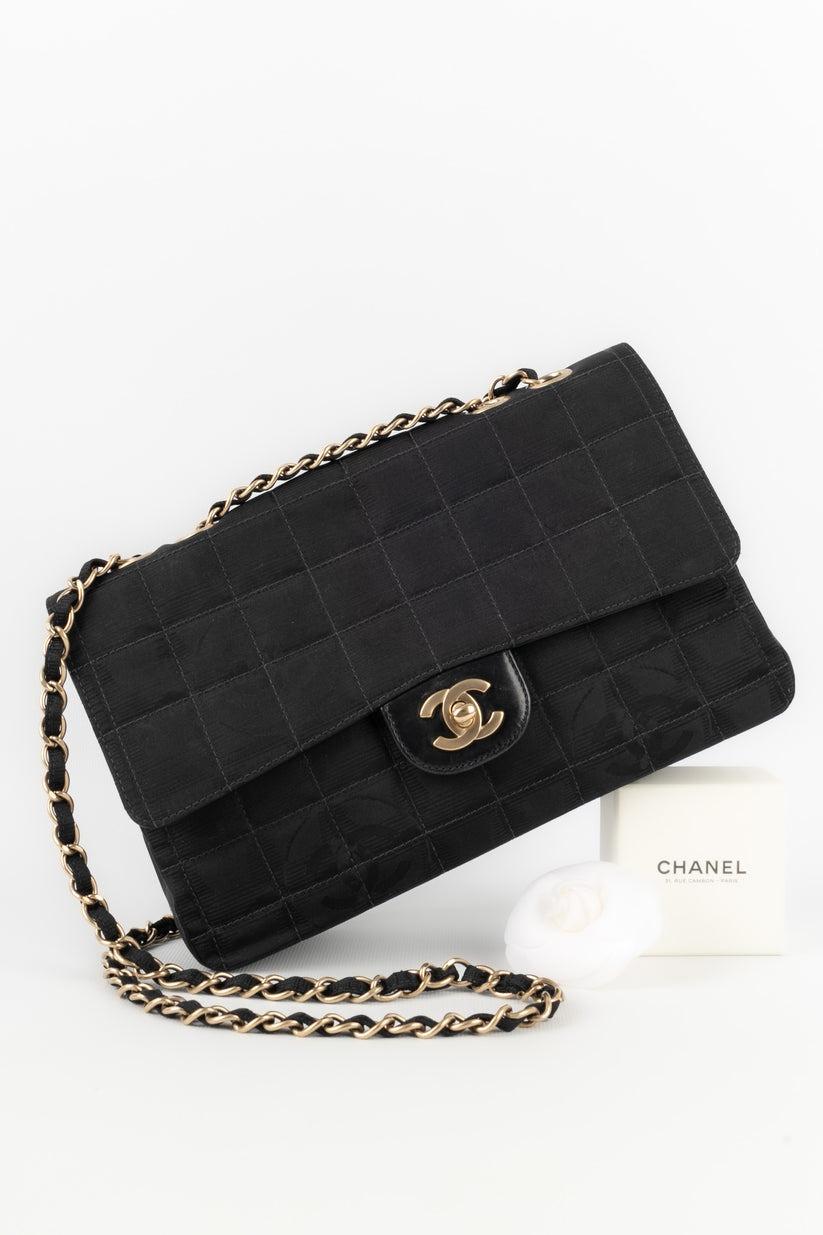 Chanel - (Made in Italy) Fabric timeless bag with a cc logo in relief and a black leather inside. Golden metal elements. Serial number. 2003/2004 Collection.

Additional information:
Condition: Very good condition
Dimensions: Height: 16 cm - Length:
