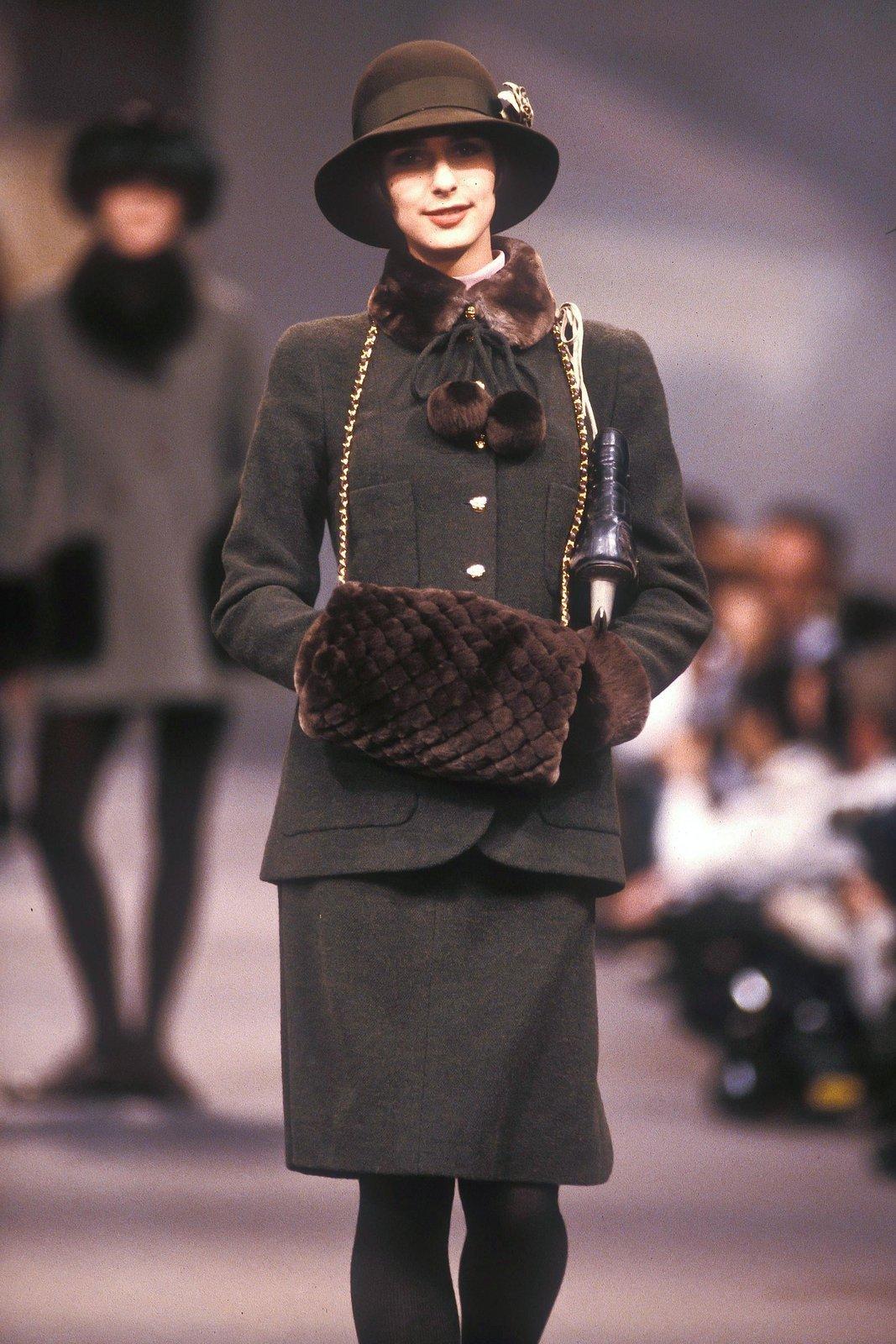 Vintage Chanel
By Karl Lagerfeld 
Fall 1989 - seen on the runway 

Green boucle jacket and skirt suit set
Brown fur collar, cuffs and pom pom scarf
Pom poms on string are detachable, could also be worn as a belt around the waist
Gold tone CC