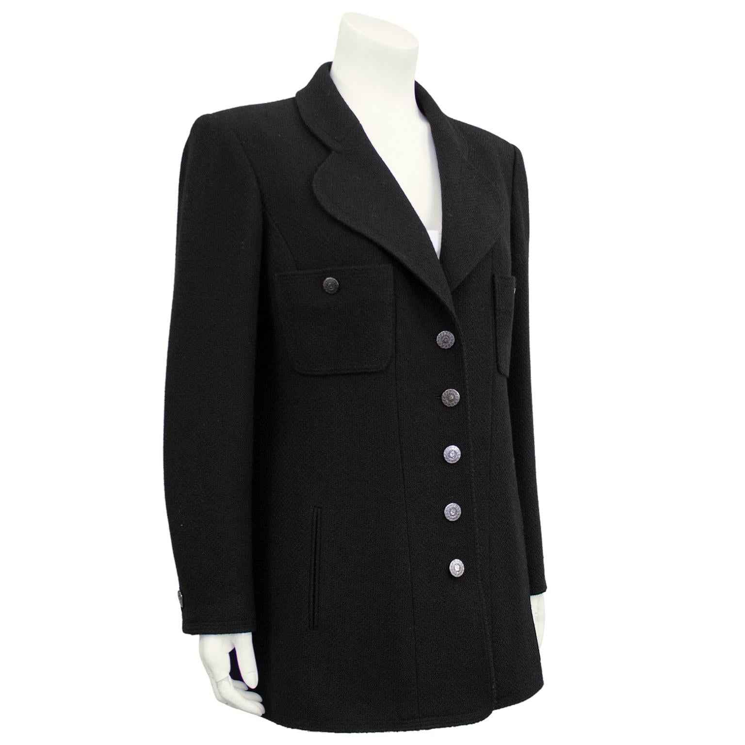 Classic and always chic Chanel black wool jacket from the Fall 1997 collection. Long sleeve with two patch pockets at bust and slanted slit pockets at hips. Silver detailed cc logo buttons down front, on patch pockets and at cuffs. Strong shoulder