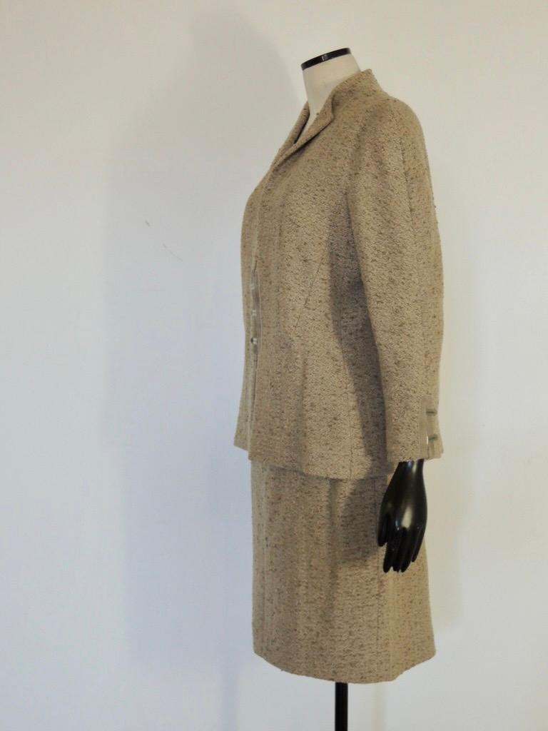 Wool boucle Chanel skirt suit from Autumn 1999. The jacket has logo hook closures at the front and at the sleeve cuffs. CC printed silk lining with inner chain detail. The skirt has pockets and logo buttons, bottom zip vent. 94% wool and 6% nylon.

