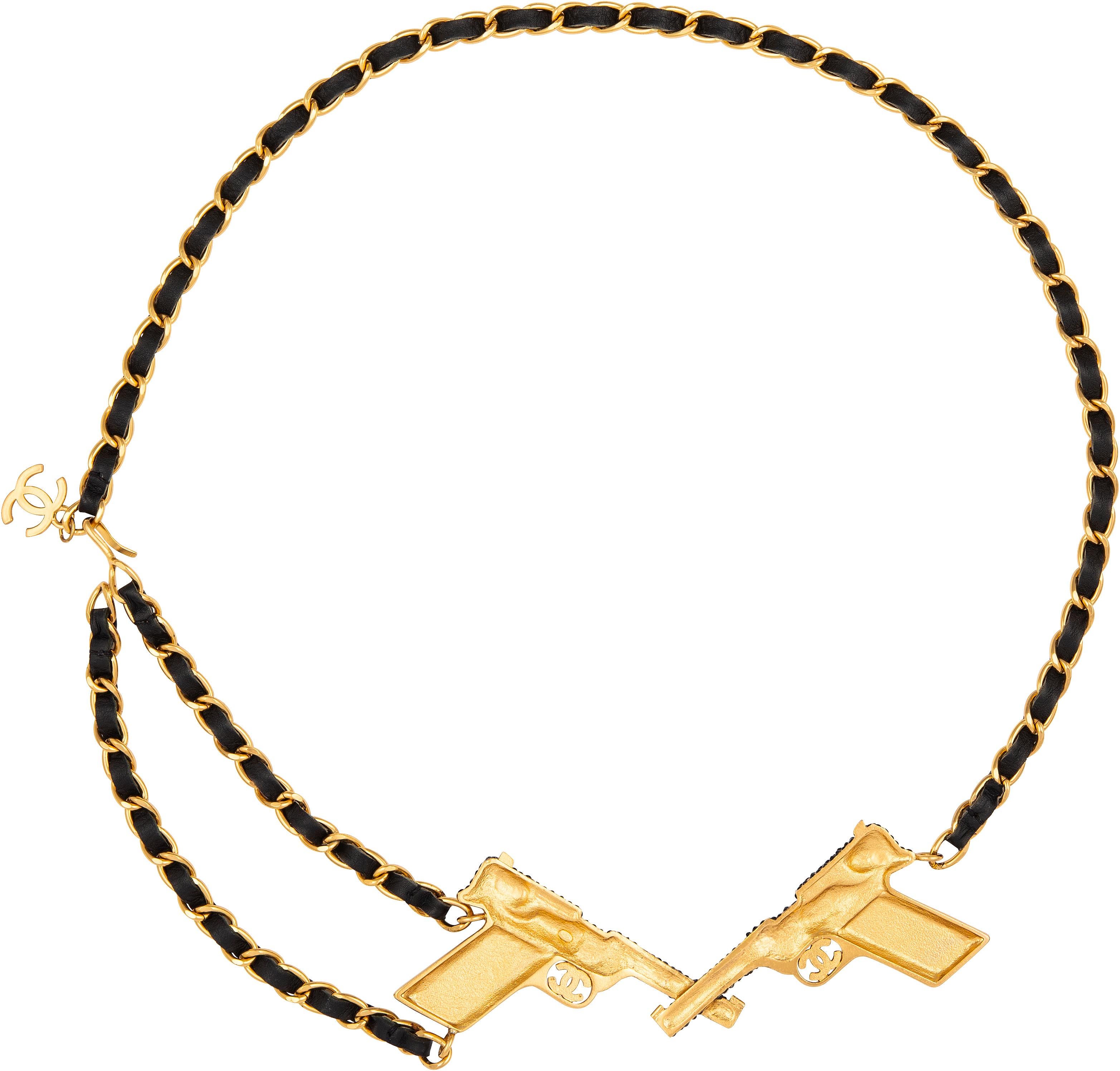 Ledergürtel mit Kettengliedern und zwei mit Swarovski verzierten Pistolen aus der Herbstkollektion 2001 von Karl Lagerfeld für Chanel.

Gesamtlänge: 36