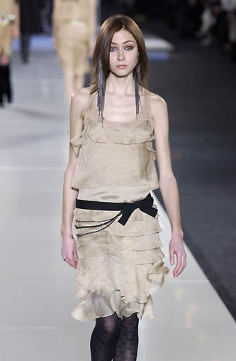 Experience luxury and sophistication with the Chanel Fall 2002 Silk Dropped Waist Dress. Made with high-quality silk, this relaxed dress features a ruffled drop waist and was originally worn with a black bow belt, as seen on the runway. Perfect for