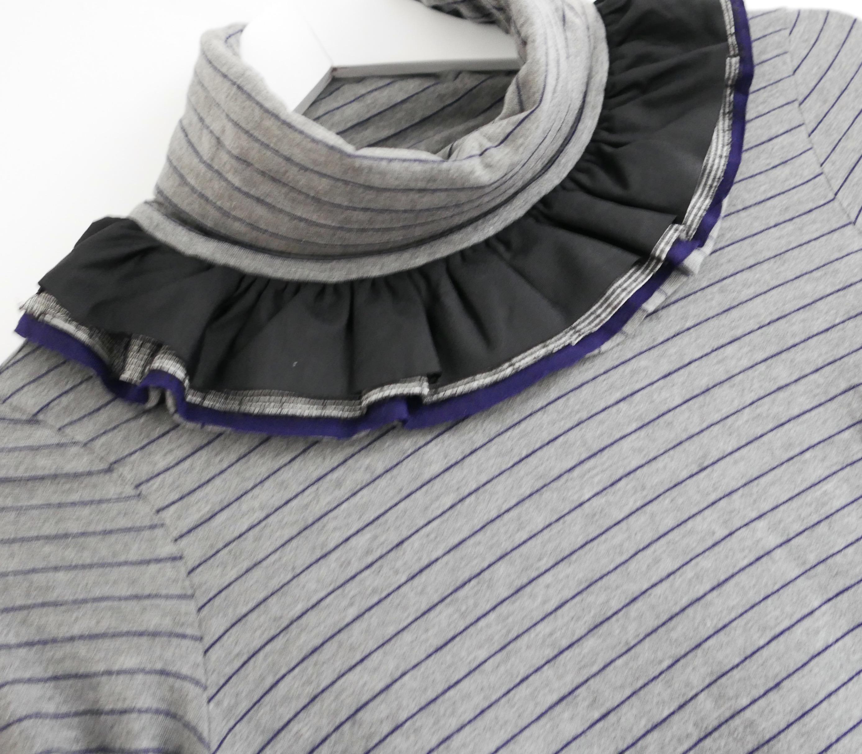 Gorgeous vintage Chanel top from the Fall 2008 08A collection. In excellent vintage condition.  Made from soft, super stretchy grey and navy striped cotton mix jersey. It has a deep roll neck, decorated with multi fabric frills and quilted cuffed