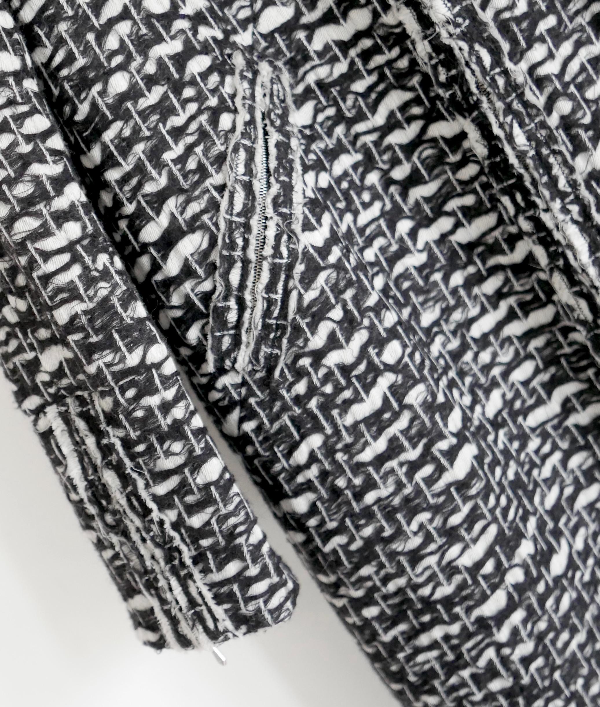 Superbe manteau léger Chanel de la Collection S 2010. Porté une fois. Réalisé en tweed fantaisie super doux à tissage lâche en laine mélangée noire et blanche, doublé de soie camélia noire. Il présente une coupe semi-décontractée, une encolure