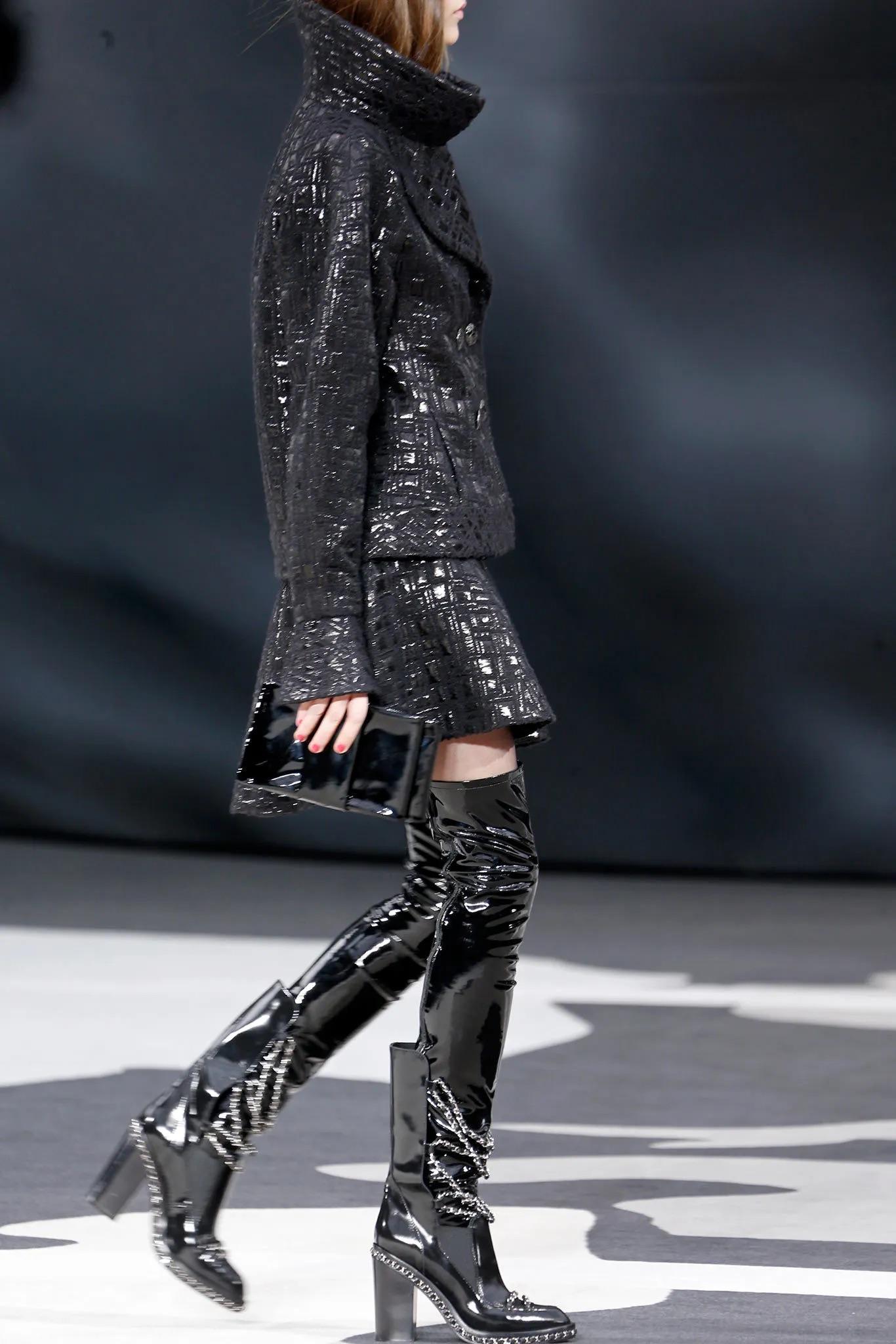 Como se han visto en Beyonce, estas botas icónicas de Chanel son una audaz reinvención del detalle de cadena característico de la marca. Confeccionadas en charol negro brillante, presentan un intrincado detalle de cadena plateada que se desliza sin