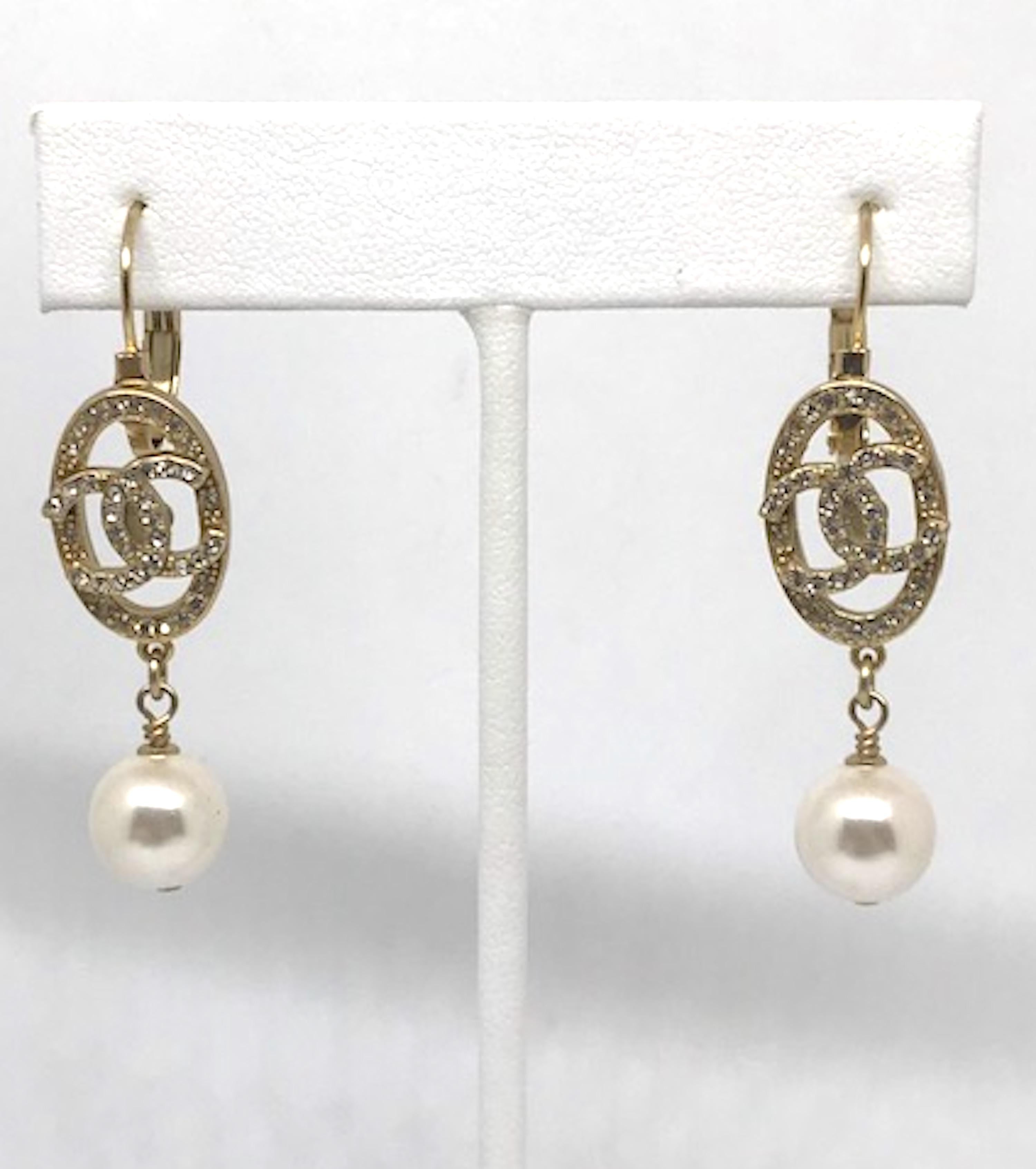 A charming pair of gold tone with rhinestone and pearl dangle Chanel CC logo earrings. French wire with lever back for pierced ears. Each earring measures just under 2 inches, or 1.88 inches long, from top of hoop to bottom of faux pearl dangle.