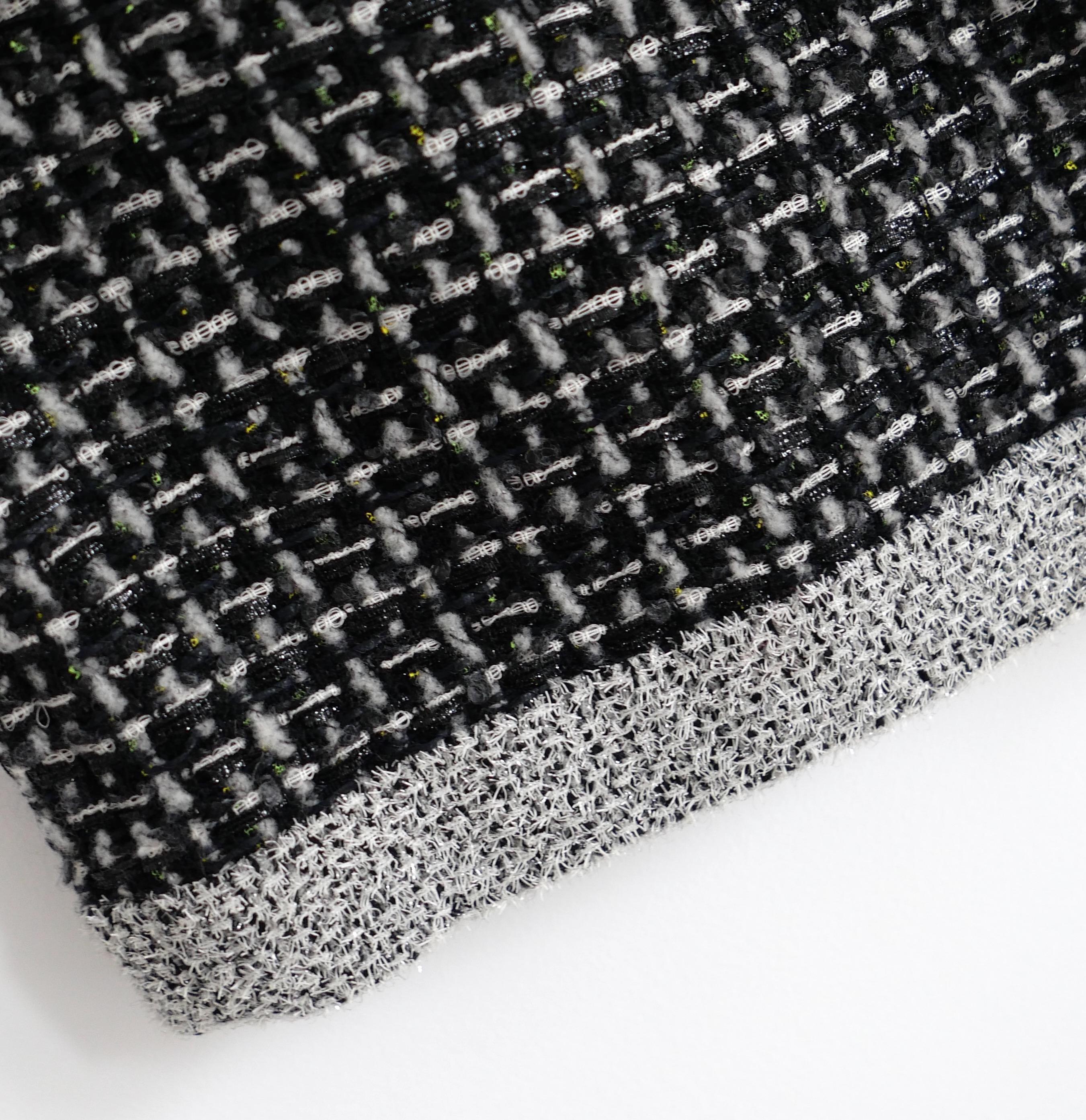 Jupe fantaisie en tweed de Chanel issue de la collection automne 2017. Non portés.  Superbement confectionné en tweed épais noir, gris et blanc ultra texturé, subtilement moucheté de néons multicolores. Il présente un ourlet en guirlande argentée et