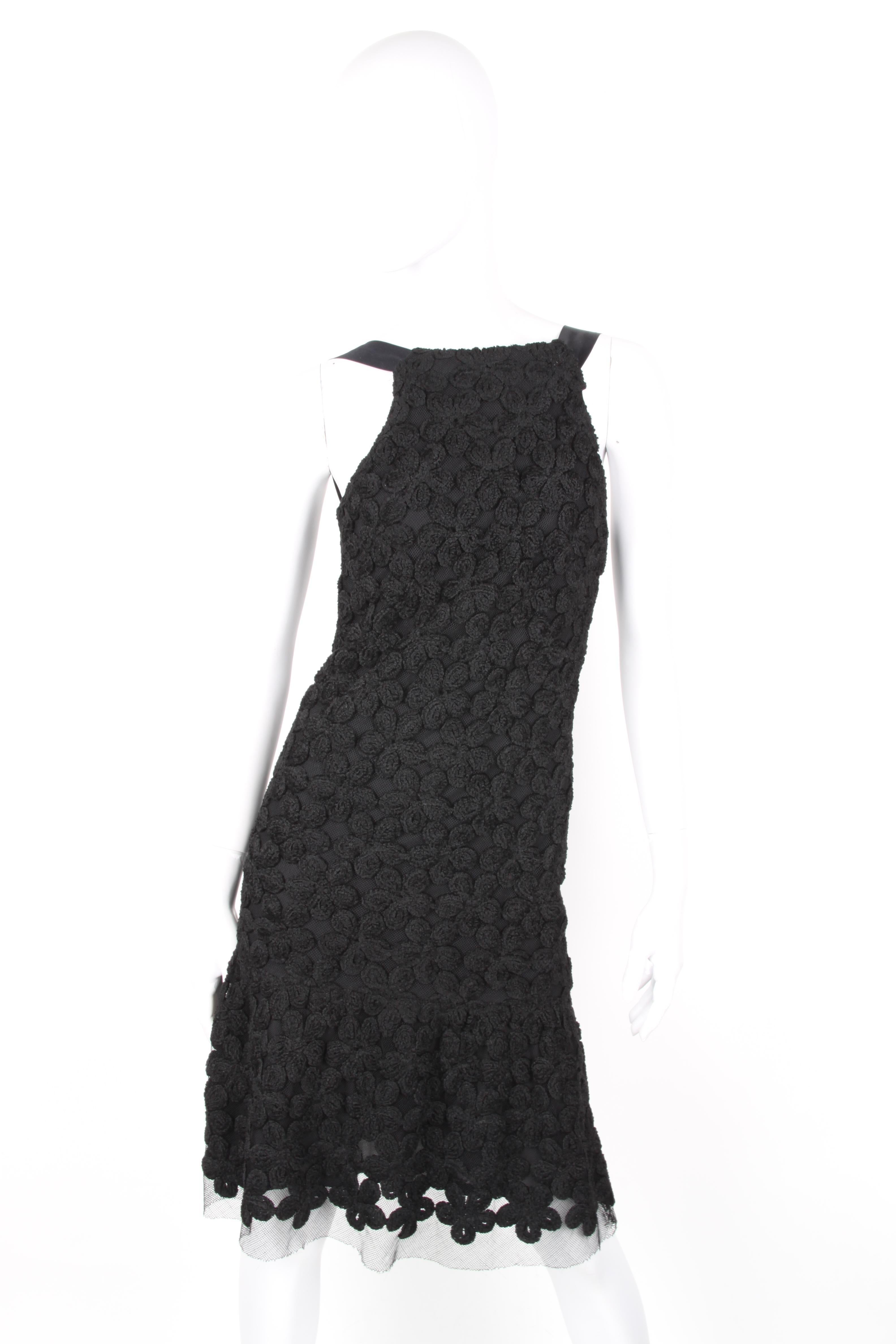 Chanel Fall/Winter 2005 Black Floral Crotchet Camelia Wool Mesh Dress.

Black wool dress accented with mesh paneling from Chanel: sheer fabric with camelia detail thoughout. Back zip and silk shouder details. Main fabric is wool and lined with