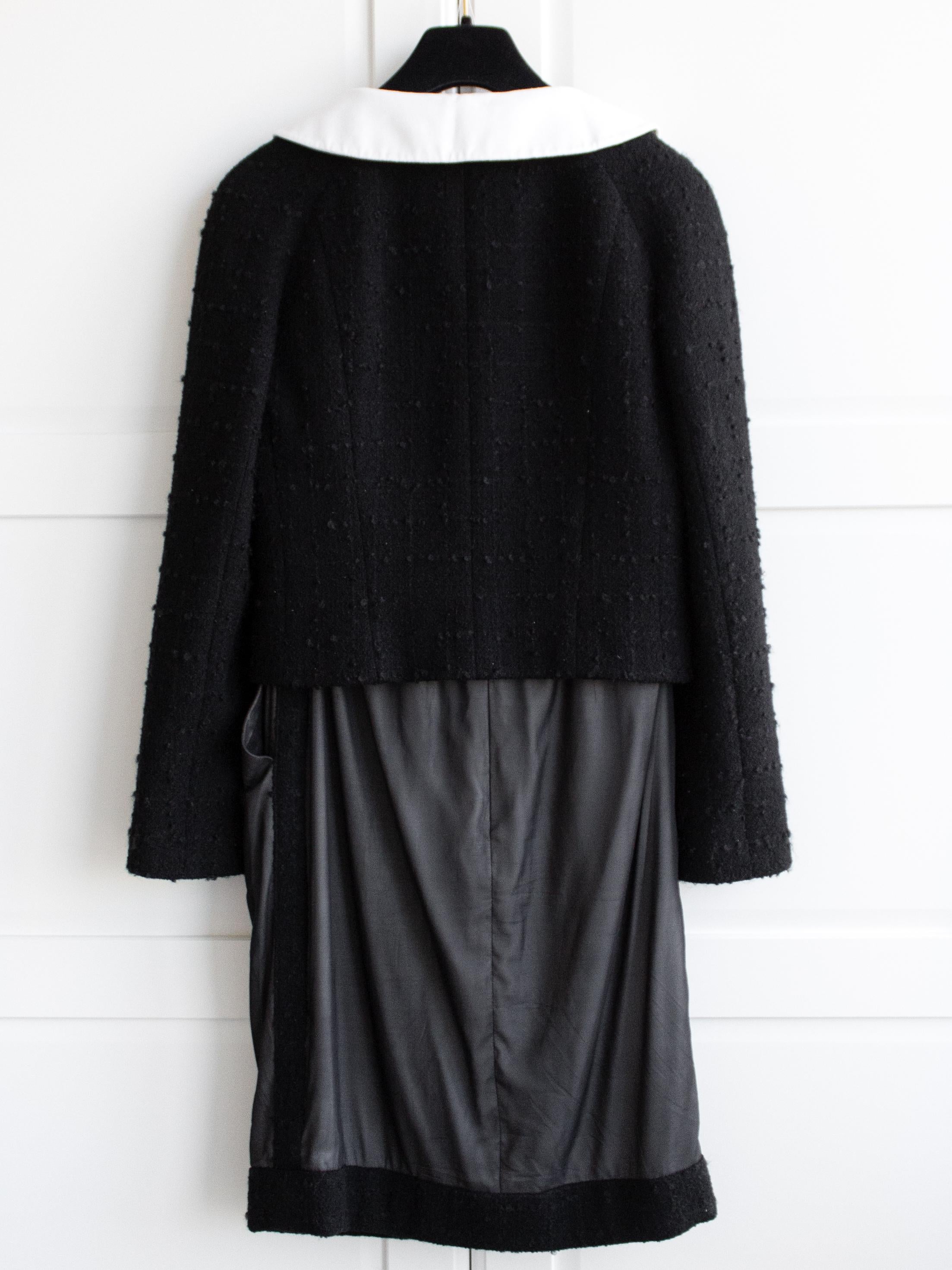 Ce tailleur intemporel et sophistiqué de la collection Chanel automne/hiver 2009 est le classique ultime. La veste noire comporte un col Claudine blanc amovible et est ornée de 17 boutons CC embellis. La jupe est réalisée en délicate soie double