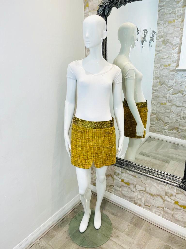 Chanel Fantasy Tweed Crystal Mini Skirt

From 2011 collection - yellow/mustard fantasy tweed in wool with 

multiple coloured threads running through. Waist band is fully adorned in golden 

crystals. Two open pockets to the front and a V shape to