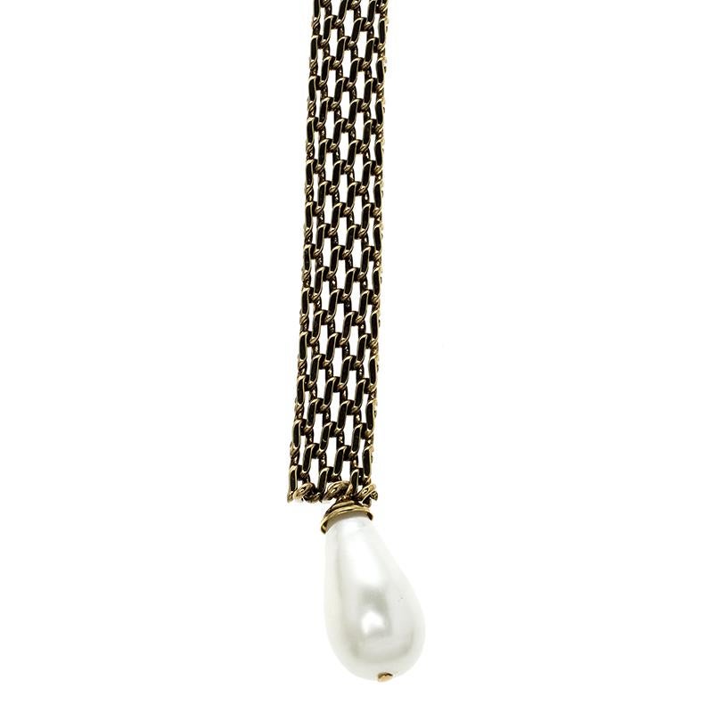 Spotted on many celebs on the red carpet, a collar necklace like this Chanel piece is a must-have in every fashionista's collection. It features a gold-tone chain collar intricately weaved with a faux pearl drop at the end. It is secured with a 'CC'