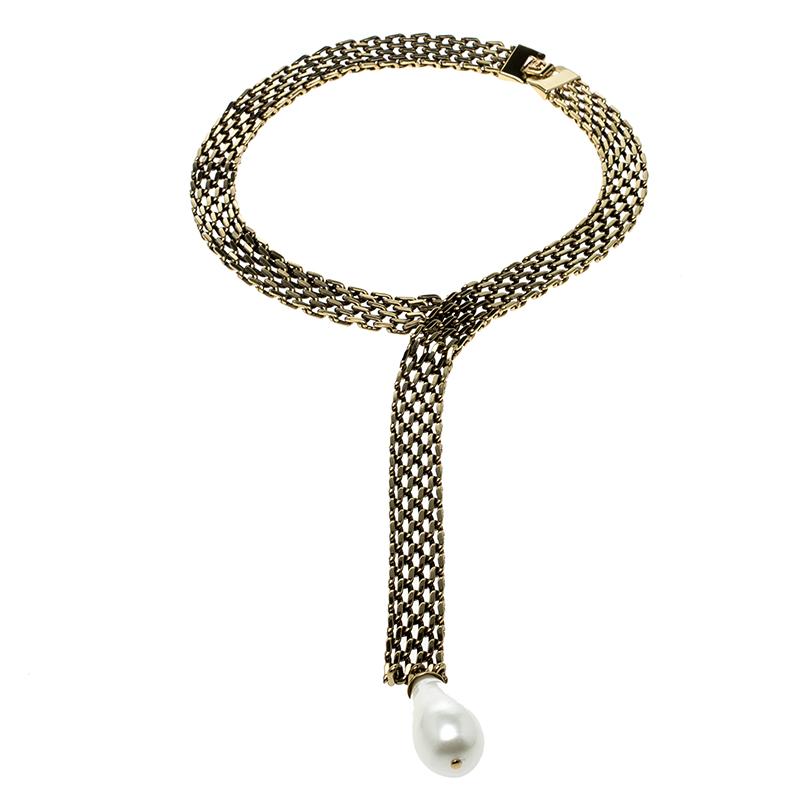 Spotted on many celebs on the red carpet, a collar necklace like this Chanel piece is a must-have in every fashionista's collection. It features a gold-tone chain collar intricately weaved with a faux pearl drop at the end. It is secured with a 'CC'