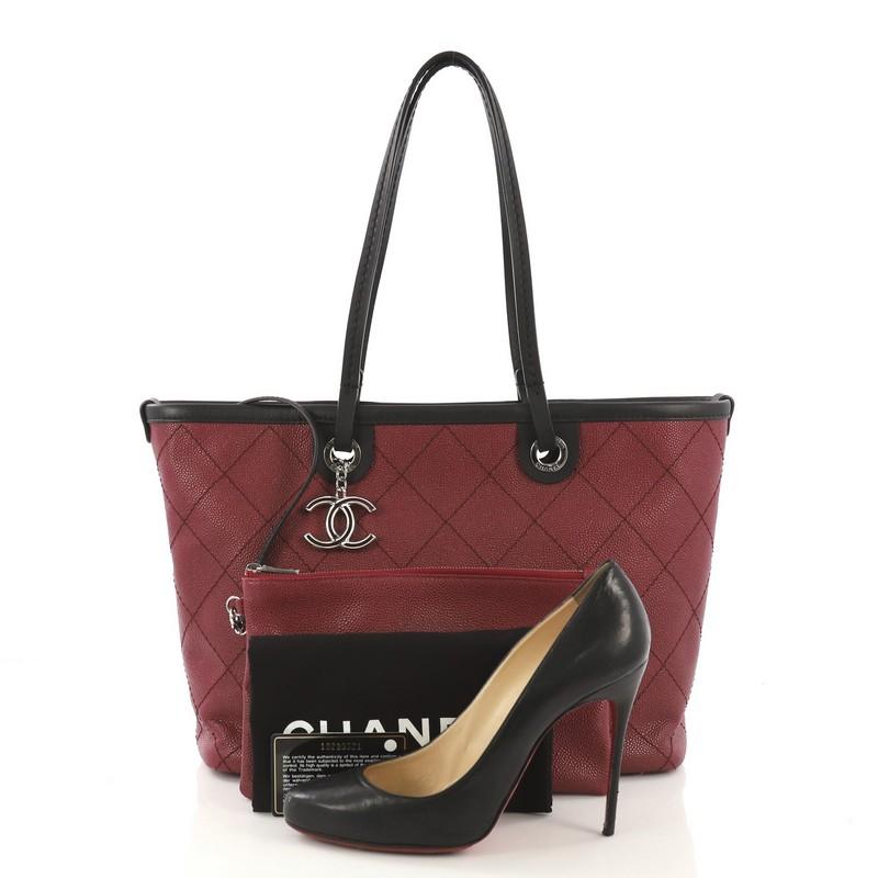 
This Chanel Fever Tote Quilted Caviar Small, crafted from burgundy quilted caviar and black leather, features dual flat leather handles, leather trim, and silver-tone hardware. Its zip closure opens to a black fabric interior with zip and slip
