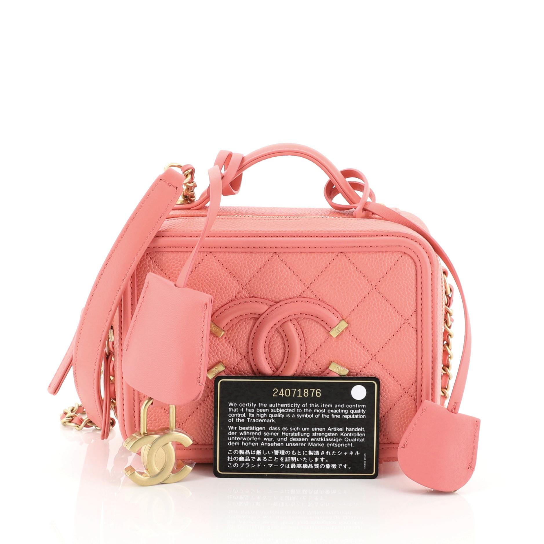 This Chanel Filigree Vanity Case Quilted Caviar Small, crafted in pink quilted caviar leather, features a leather top handle, woven-in leather chain strap, CC stitched logo at front and matte gold-tone hardware. Its zip-around closure opens to a