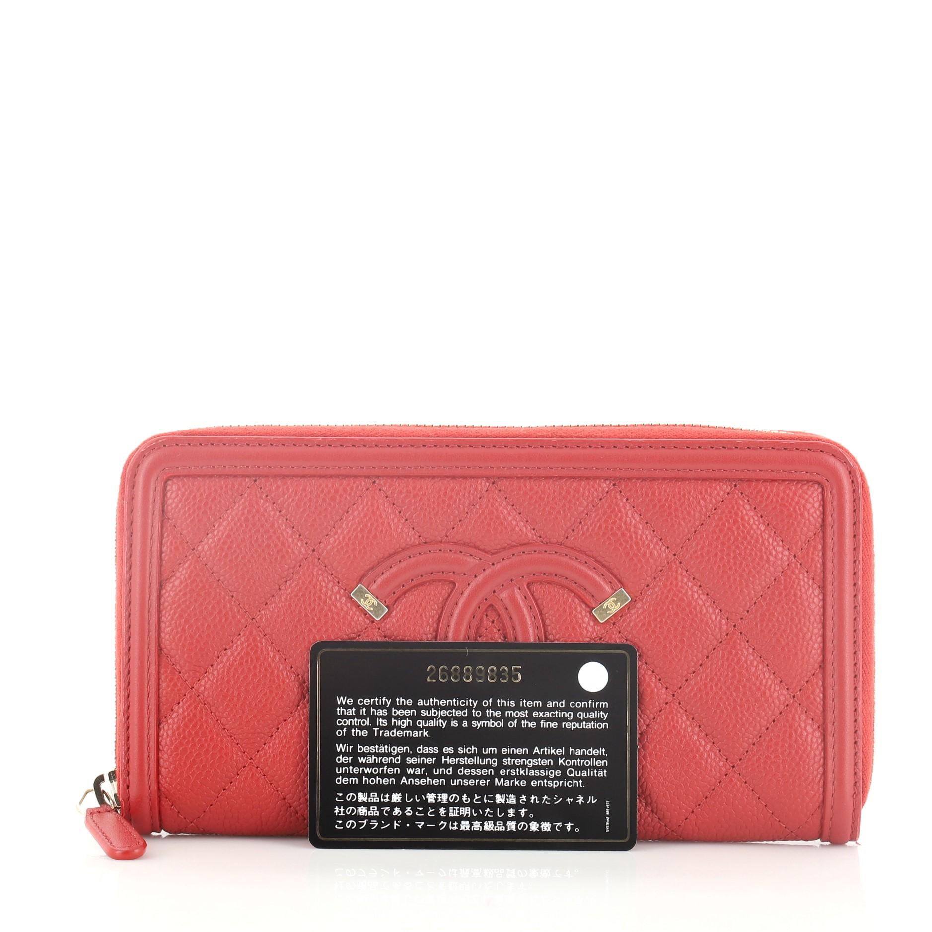 This Chanel Filigree Zip Around Wallet Quilted Caviar Long, crafted in red quilted caviar leather, features Chanel CC logo patch on the front and gold-tone hardware. Its zip around closure opens to a red leather interior with multiple card slots and