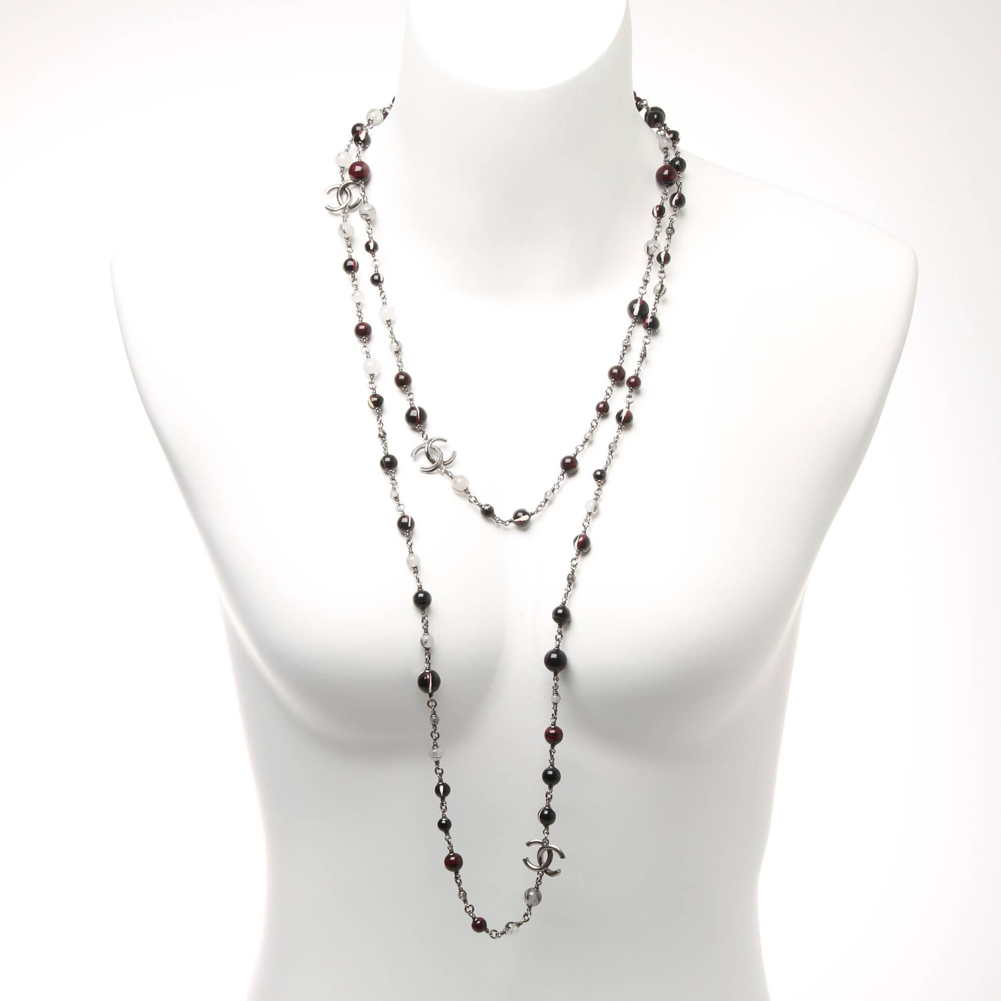 Chanel long necklace formed of black, red, white a purple marbled beads and fine silver wire. Featuring intermittent CC charms. 

Stamp 11 A