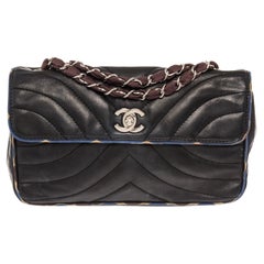 Chanel Flap shoulder bag features black Chevron quilted Lambskin leather