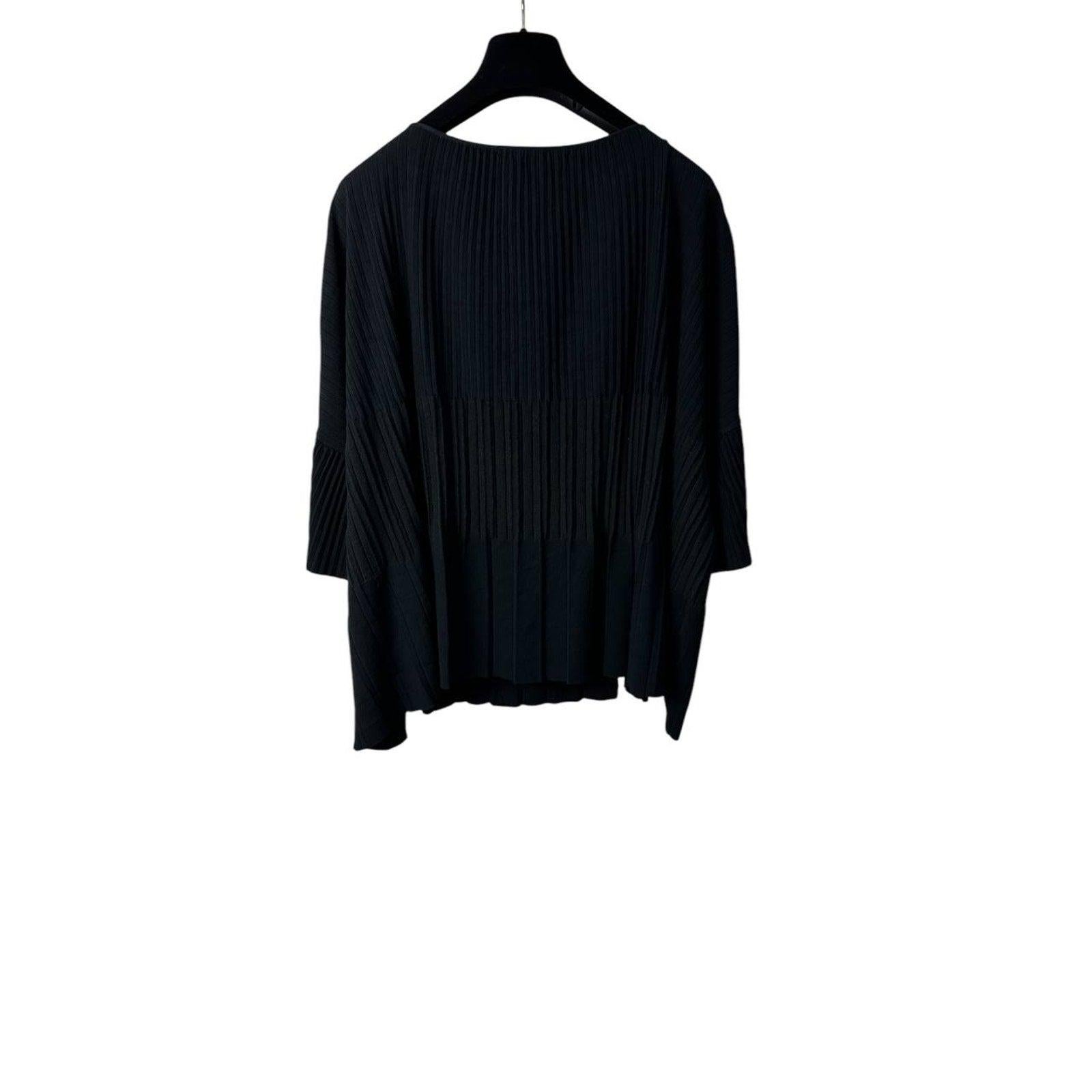 This Chanel knitted top, size 40, is a stunning blend of structure and delicate design. The flared sleeves add a touch of refined geometry, enhancing the overall look. 

The loose fit ensures a relaxed and comfortable silhouette, while the deep