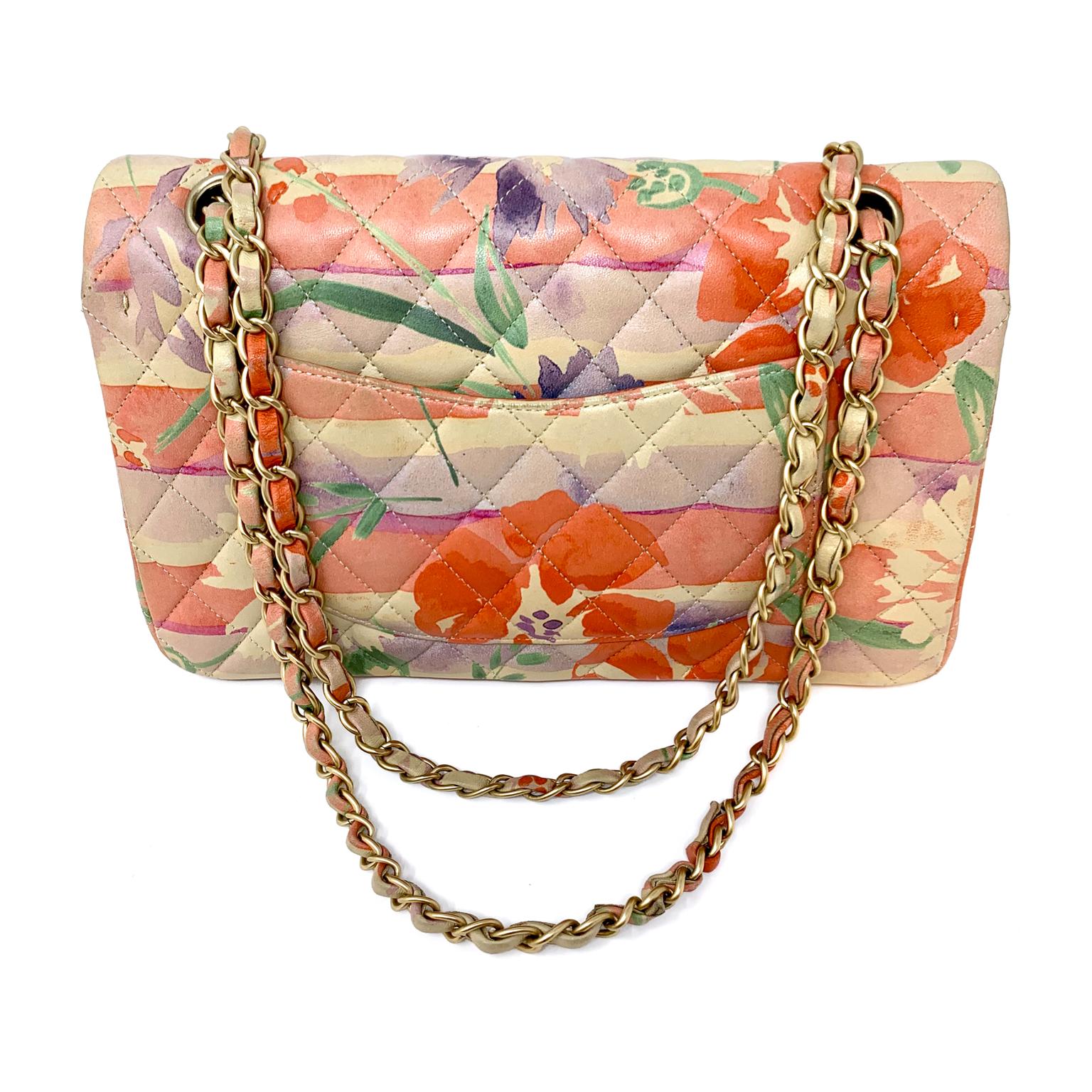 This authentic Chanel Floral Watercolor Double Flap Bag is in excellent condition.  Signature Chanel quilted leather design in serene multicolor floral.  Shades of orange, purple, green and blue flow together on a soft yellow- gold background. 