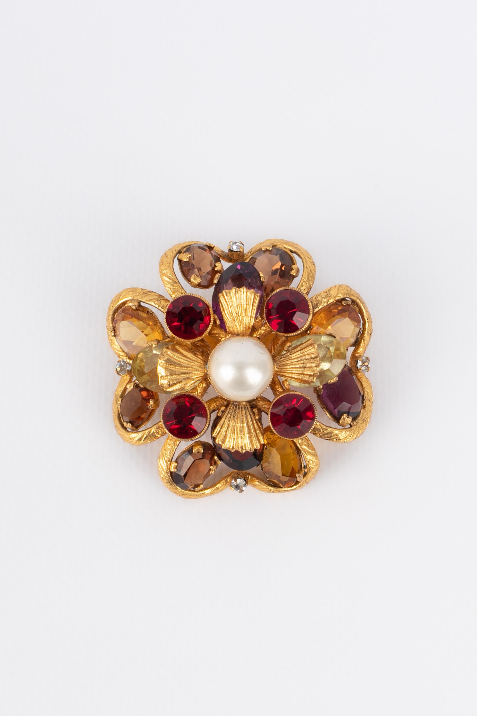 CHANEL - (Made in France) Golden metal brooch representing a flower ornamented with rhinestones and a costume pearly cabochon. Jewelry from the 1960s/1970s.

Condition:
Very good condition

Dimensions:
5 cm x 5 cm

BRB69