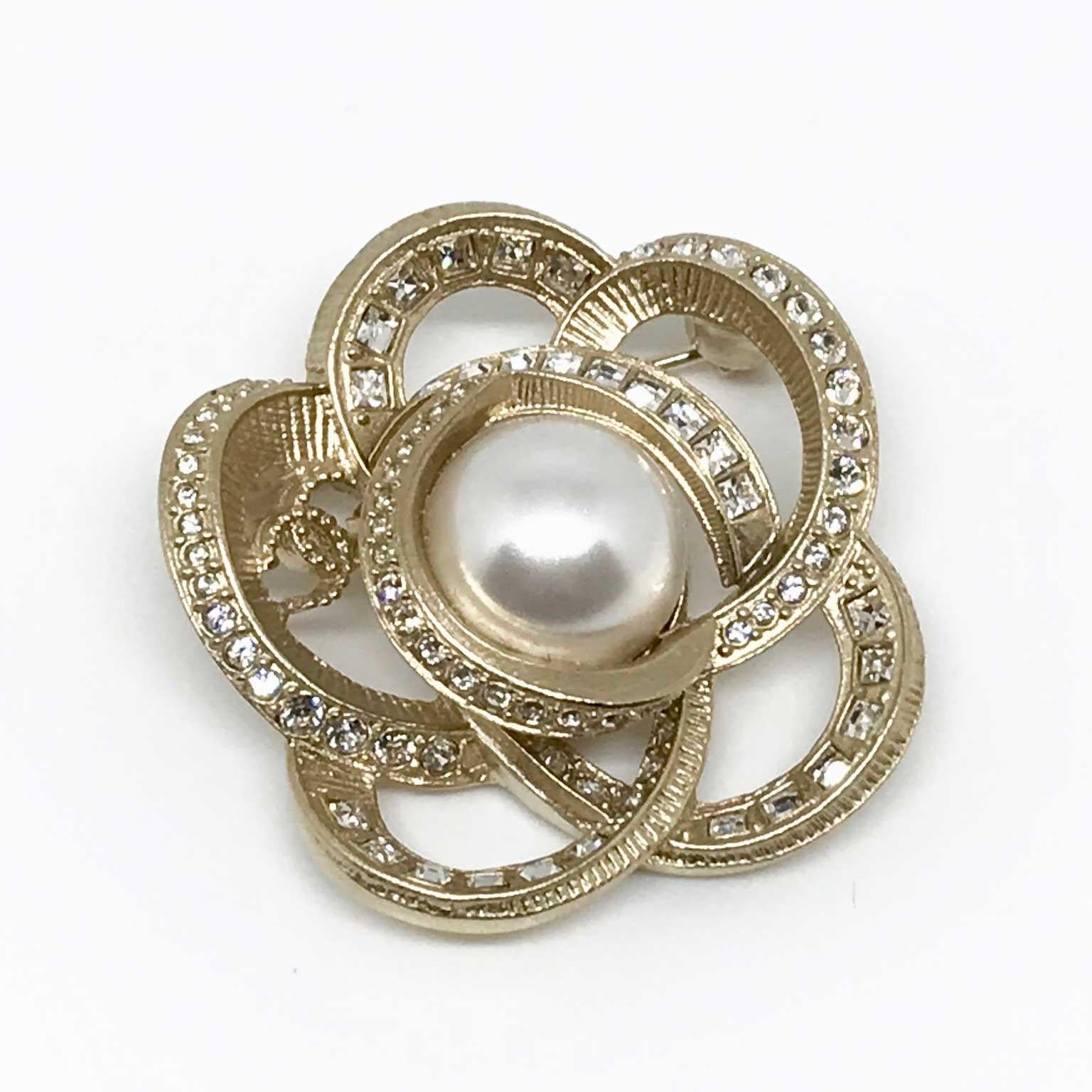 Superb Chanel brooch from the Spring / Summer 2018 Collection. It is in the shape of a flower entirely set with rhinestones, a golden CC is in the heart of a petal. The flower bud is a pearly pearl.
This Chanel flower brooch measures 4.3 cm in