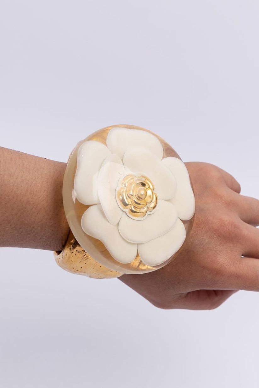 Chanel- Cuff bracelet in gilded metal decorated with a large resin flower. Signed on a plate.

Additional information:
Dimensions: Flower diameter: 9 cm (3.54
