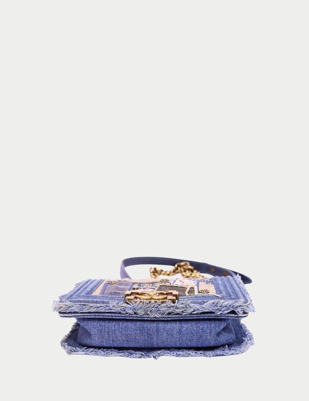 Celebra l'audacia dell'artigianato con questa Chanel Boy Bag in Denim Patchwork, una rara creazione in edizione limitata che mette in mostra l'estro artistico della Maison. Progettato con un mix di texture denim, dettagli sfrangiati e pannelli
