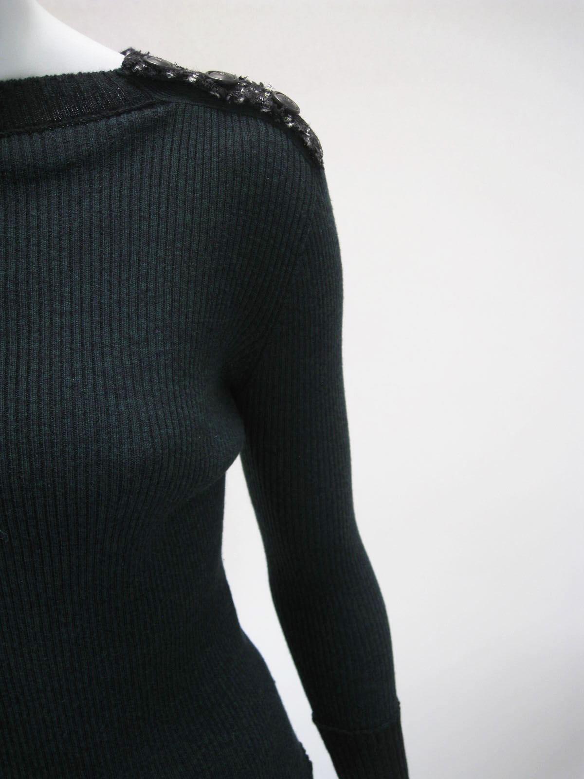 Chanel forest green and black ribbed knit sweater.

Deep green and black marled color.

Contrasting darker neckline and cuff.

Shoulder features black (with green and white) tweed epaulets with CC buttons.

Very clingy and stretchy.

Fabric is 90%