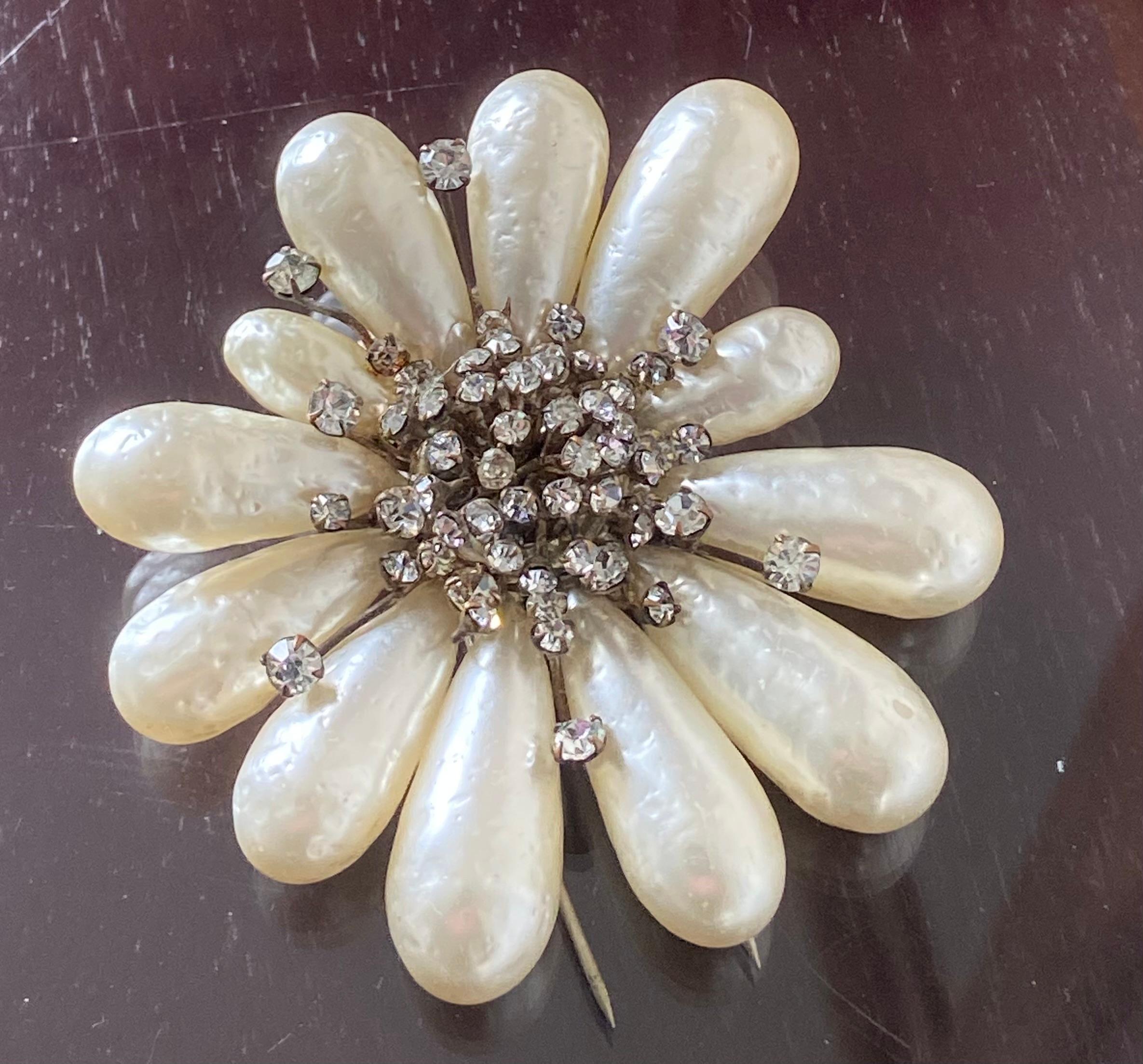 Qué alfiler de piel más impresionante.

Lo hemos datado en los años 50 y hecho para Chanel .
Un alfiler impresionante  fabricado por la Maison Gripoix.

La calidad de las perlas barrocas de cristal Gripoix es sublime, y forman un círculo floral,
